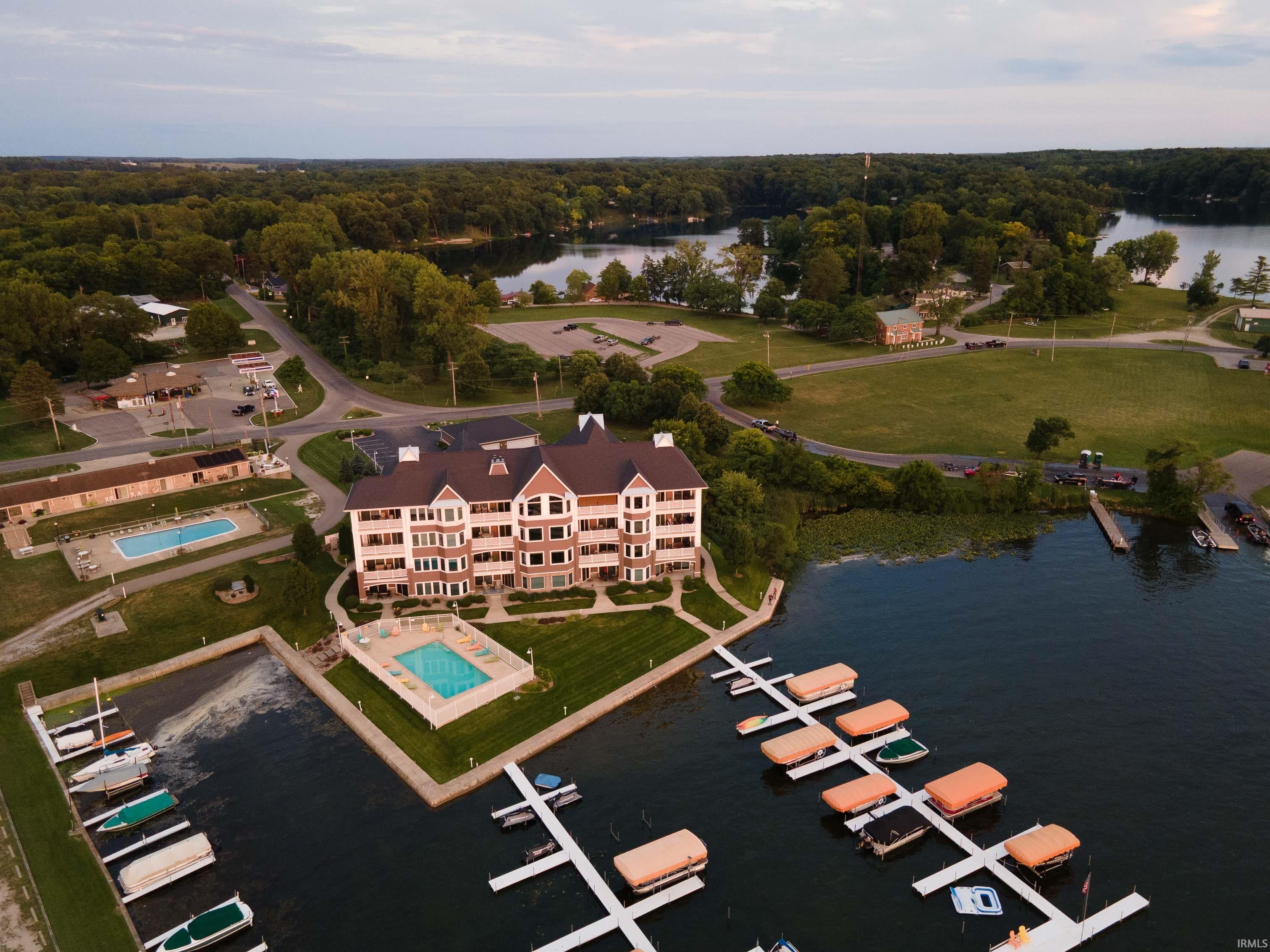 Image 3: Waterfront condominium complex featuring a multi-story facade with balconies, an outdoor swimming pool, and boat docks, Aerial View Image 3: Waterfront condominium complex featuring a multi-story facade with balconies, an outdoor swimming pool, and boat docks, Aerial View