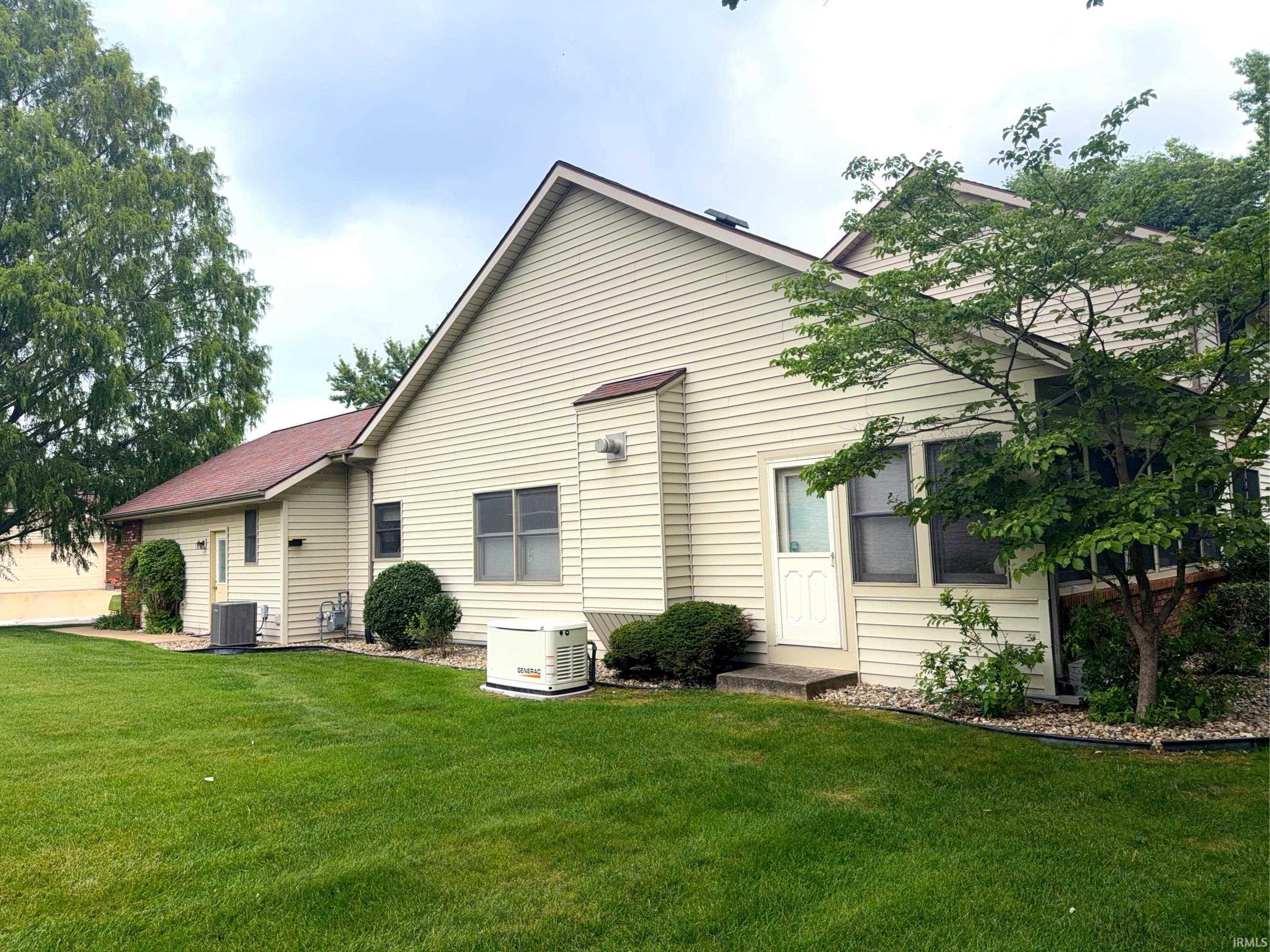 Image 3: Side exterior featuring horizontal siding, a red-hued shingle roof, a dedicated generator unit, and a mature shade tree, Back Of Structure Image 3: Side exterior featuring horizontal siding, a red-hued shingle roof, a dedicated generator unit, and a mature shade tree, Back Of Structure