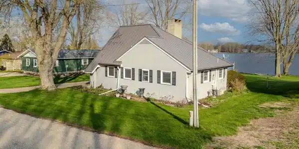 Image 2: View of front of home featuring a chimney, a front yard, and a metal roof, Front Of Structure Image 2: View of front of home featuring a chimney, a front yard, and a metal roof, Front Of Structure