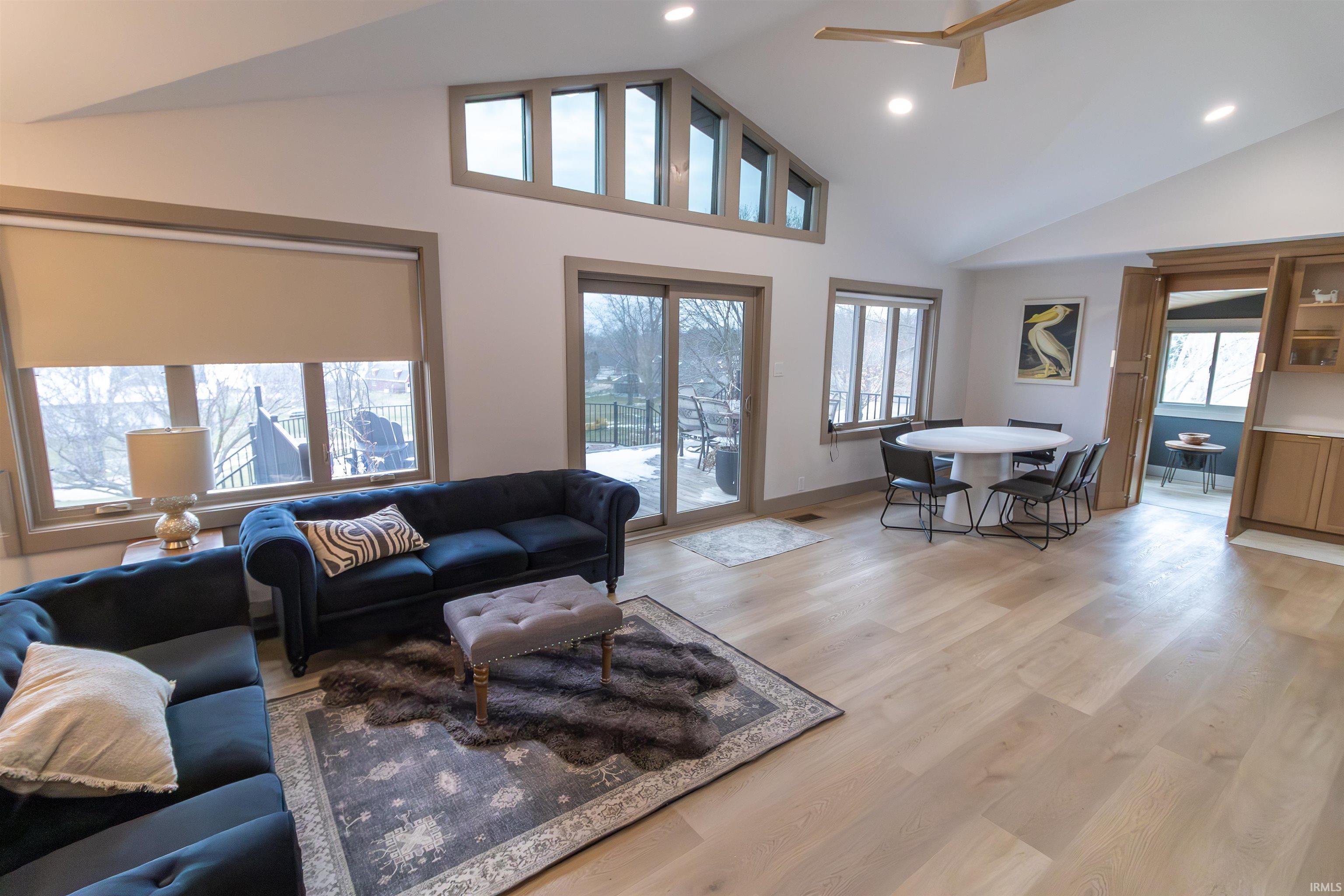 Image 1: Living area with light wood-style flooring, recessed lighting, and vaulted ceiling, Living Room