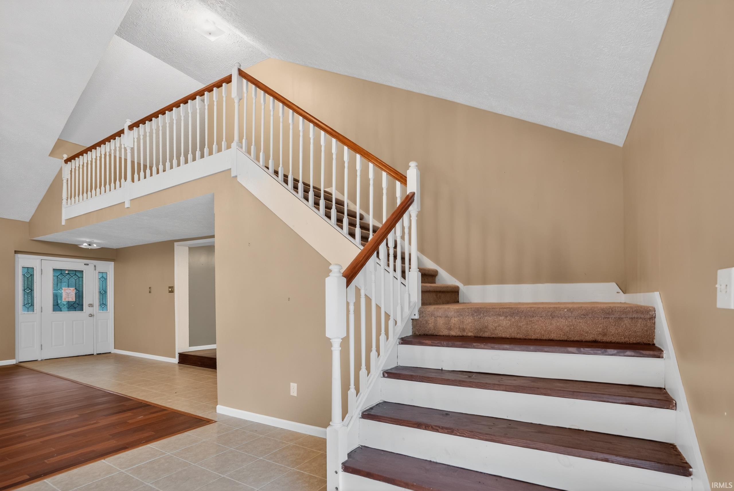 Image 3: Grand entryway featuring a two-story foyer with a vaulted ceiling, Stairs