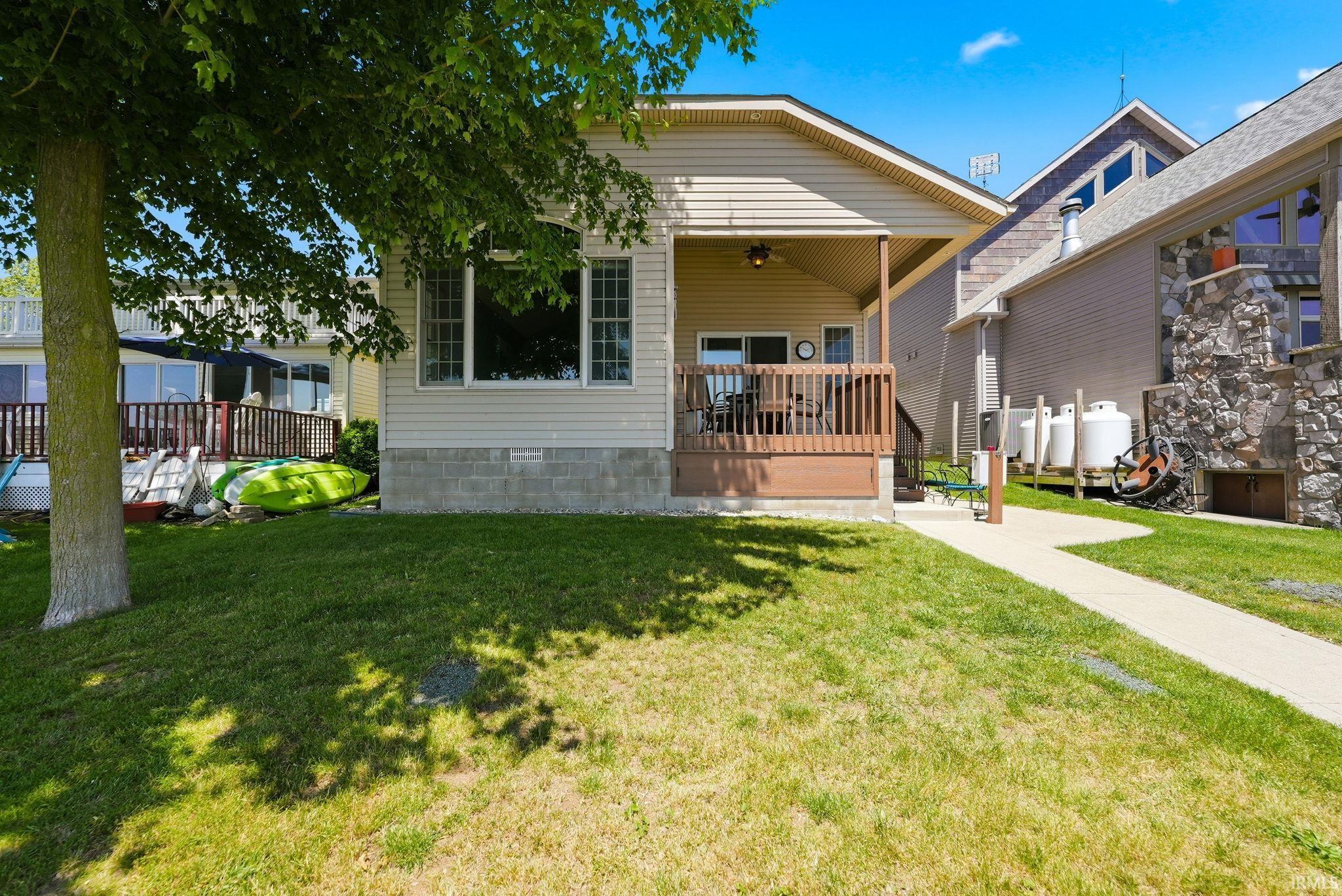 Image 0: Front facade with tan siding and a covered porch, Front Of Structure Image 0: Front facade with tan siding and a covered porch, Front Of Structure