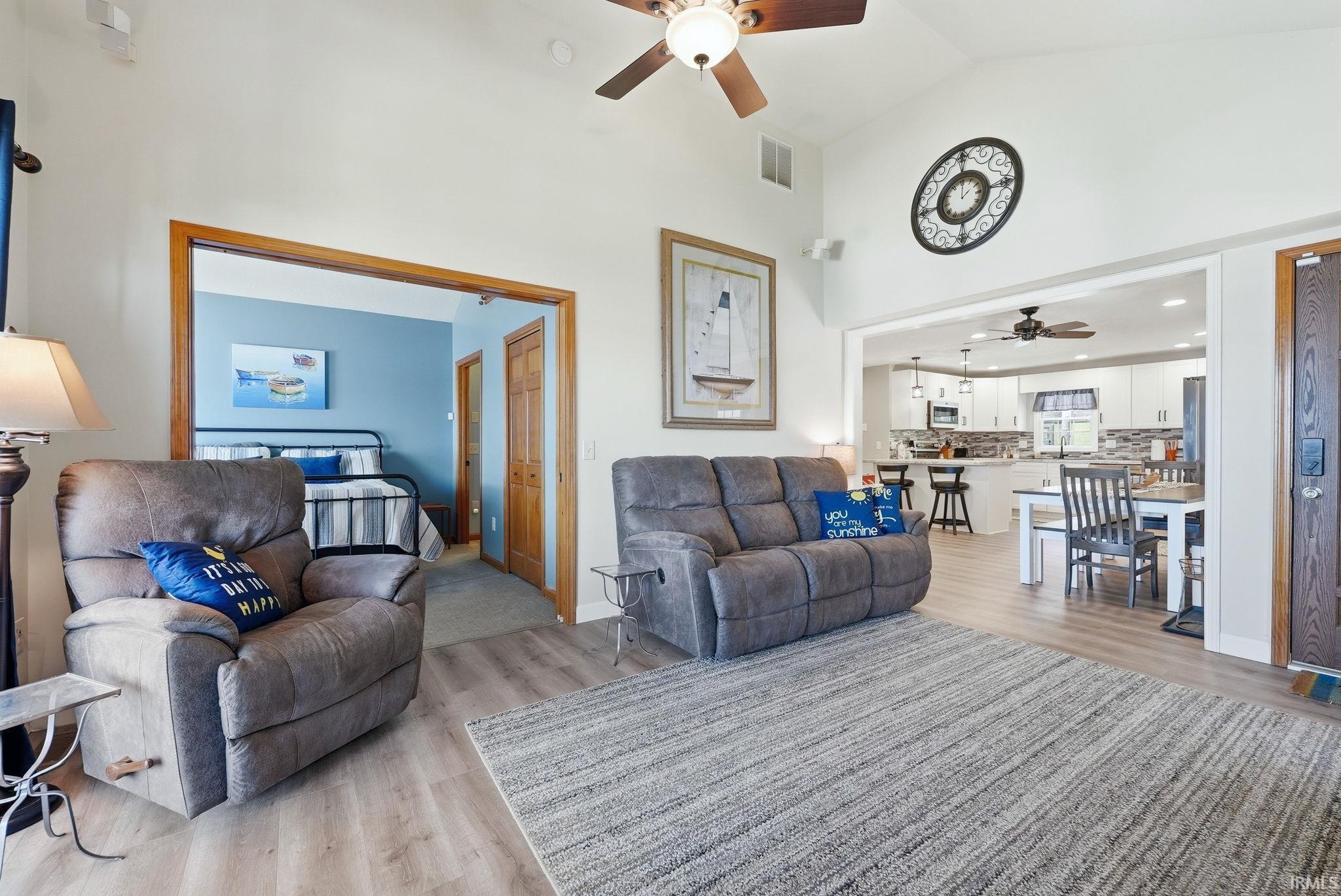 Image 3: Living area featuring vaulted ceilings, wood-finish flooring, and an open-concept layout, Living Room Image 3: Living area featuring vaulted ceilings, wood-finish flooring, and an open-concept layout, Living Room