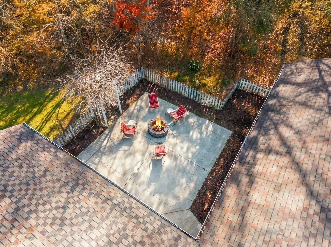 Image 2: Picket-fenced concrete patio featuring a built-in fire pit, Aerial View Image 2: Picket-fenced concrete patio featuring a built-in fire pit, Aerial View