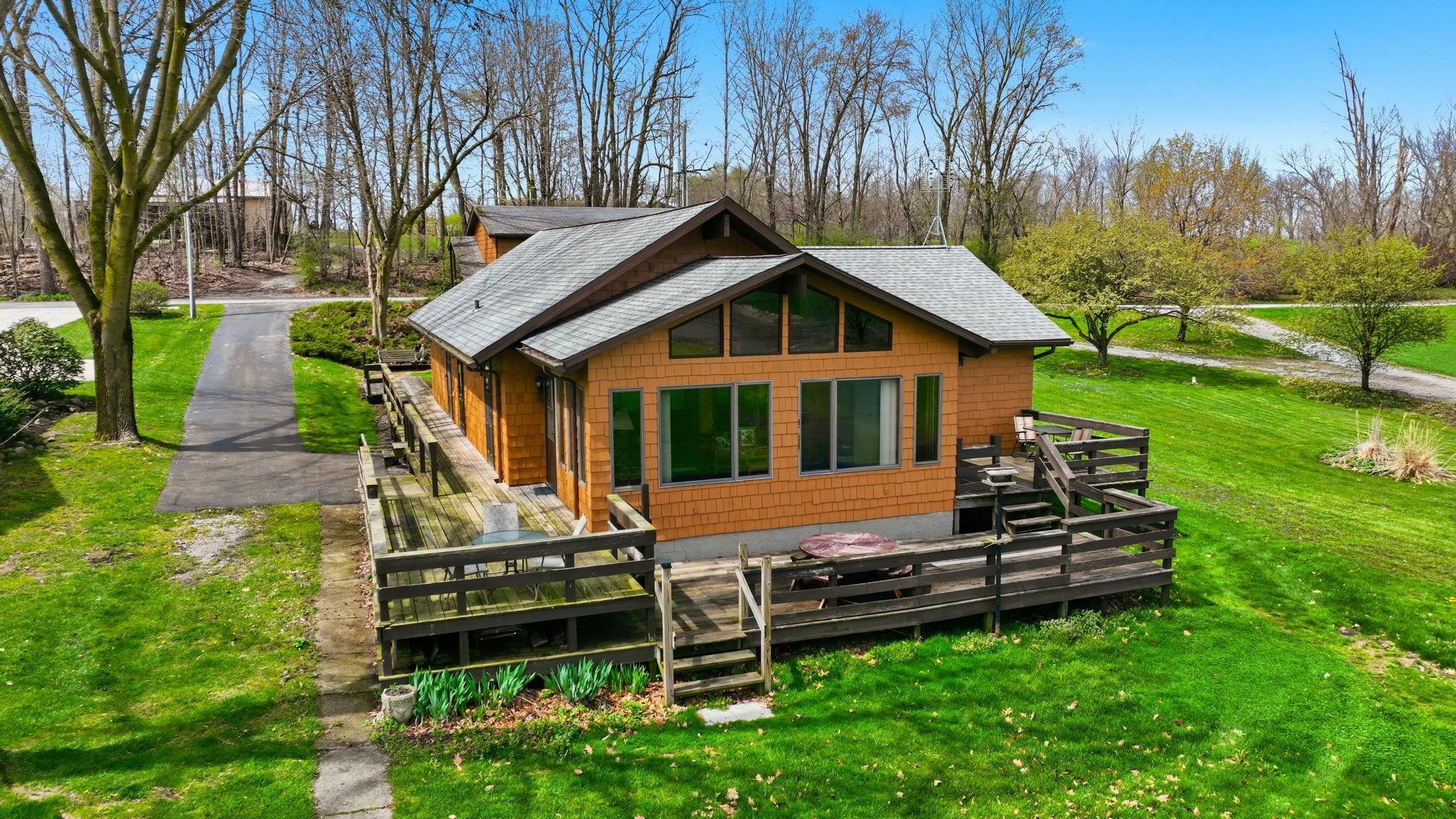 Image 0: Rear view of property featuring a yard, a deck, and roof with shingles, View - Primary Front Image 0: Rear view of property featuring a yard, a deck, and roof with shingles, View - Primary Front