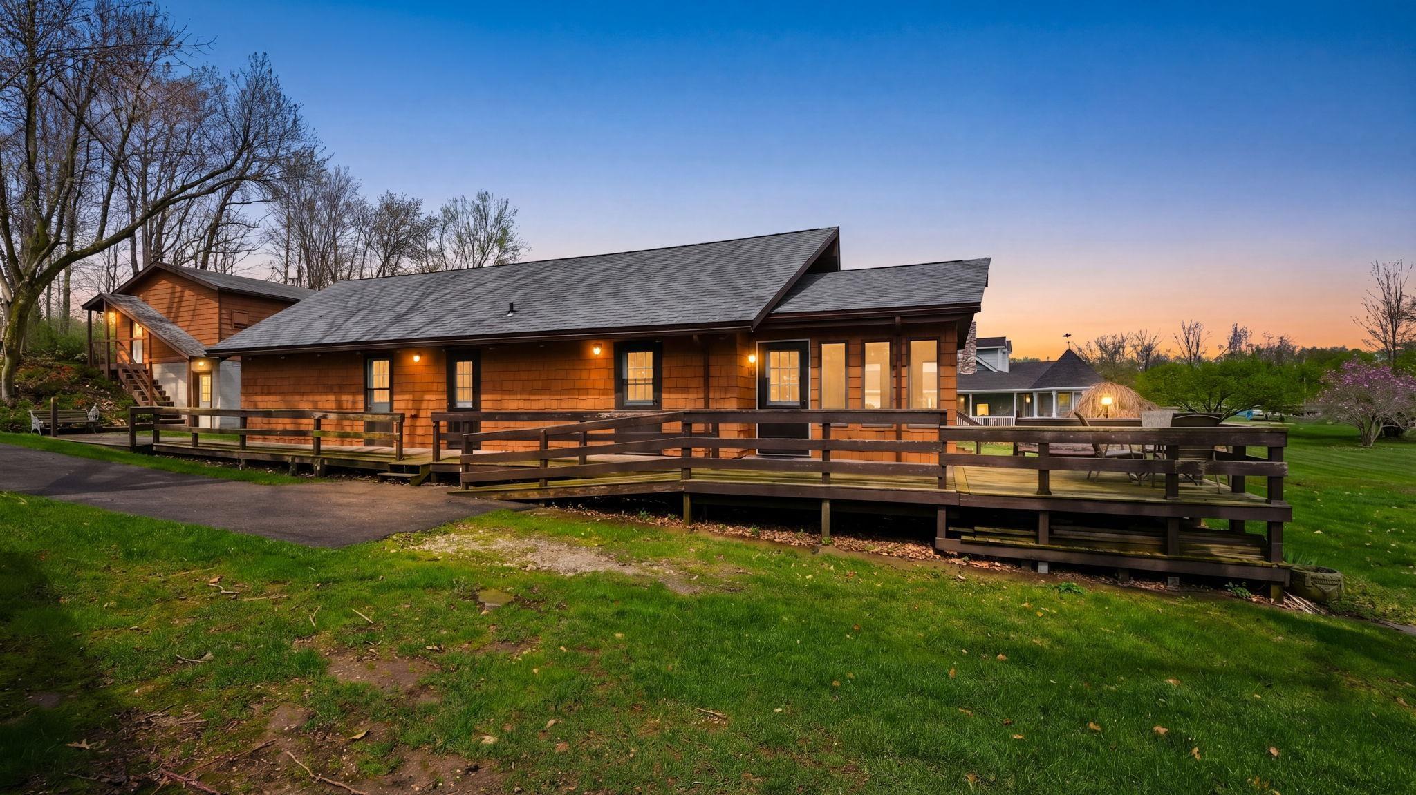 Image 2: View of front of property with a front yard and a wooden deck, View - Primary Side Image 2: View of front of property with a front yard and a wooden deck, View - Primary Side