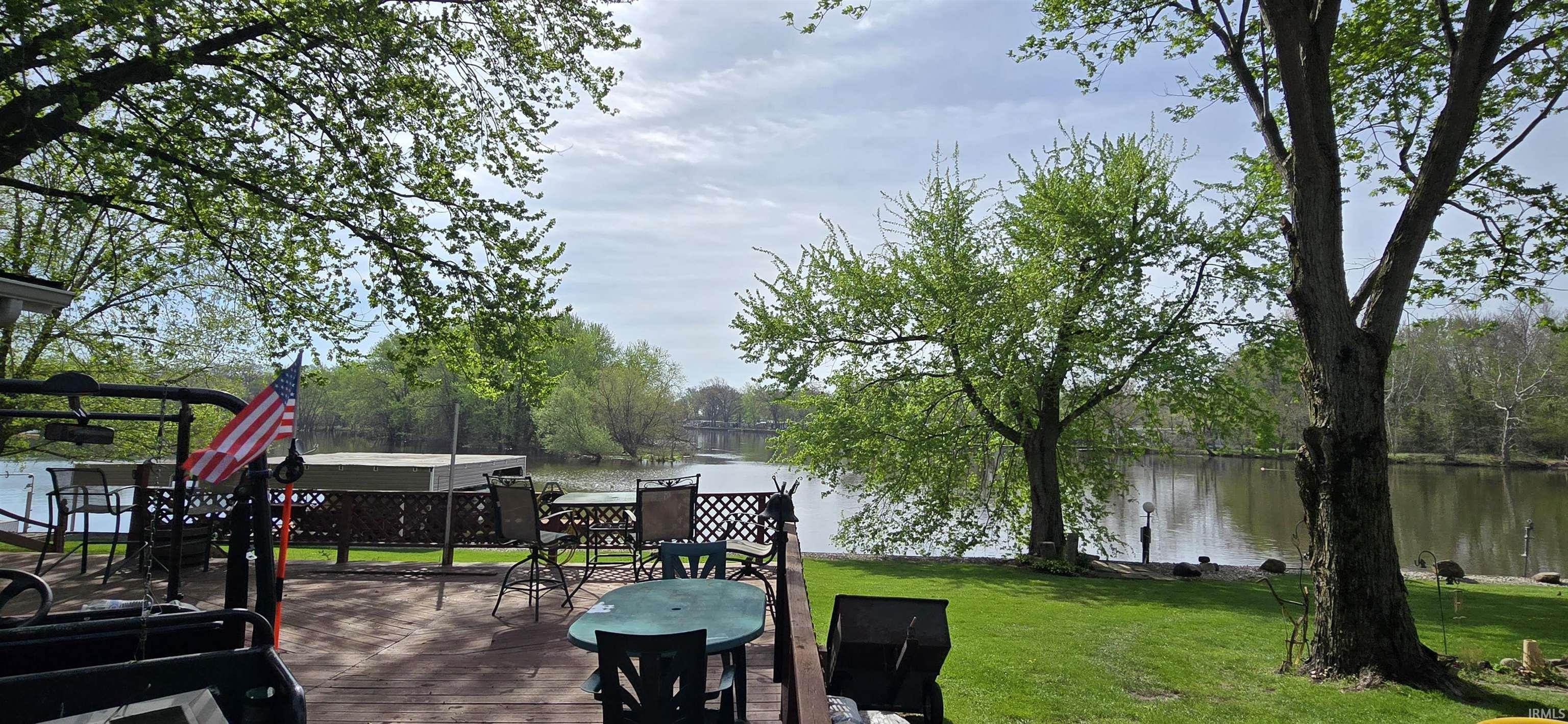 Image 2: View of patio with outdoor dining area and a deck with water view, Patio