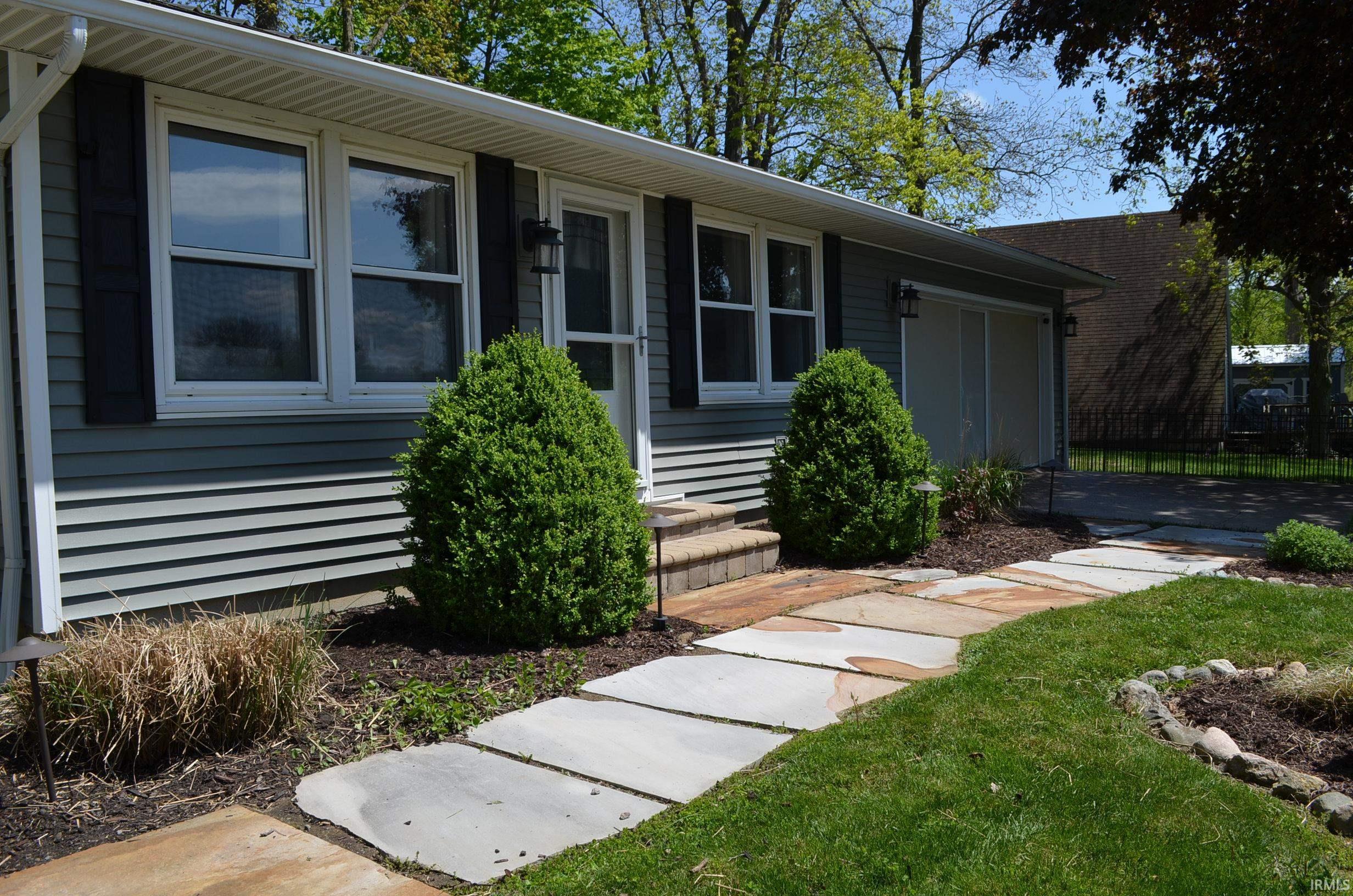 Image 3: Ranch-style exterior with blue horizontal siding, black window shutters, and a white screen door, Front Of Structure