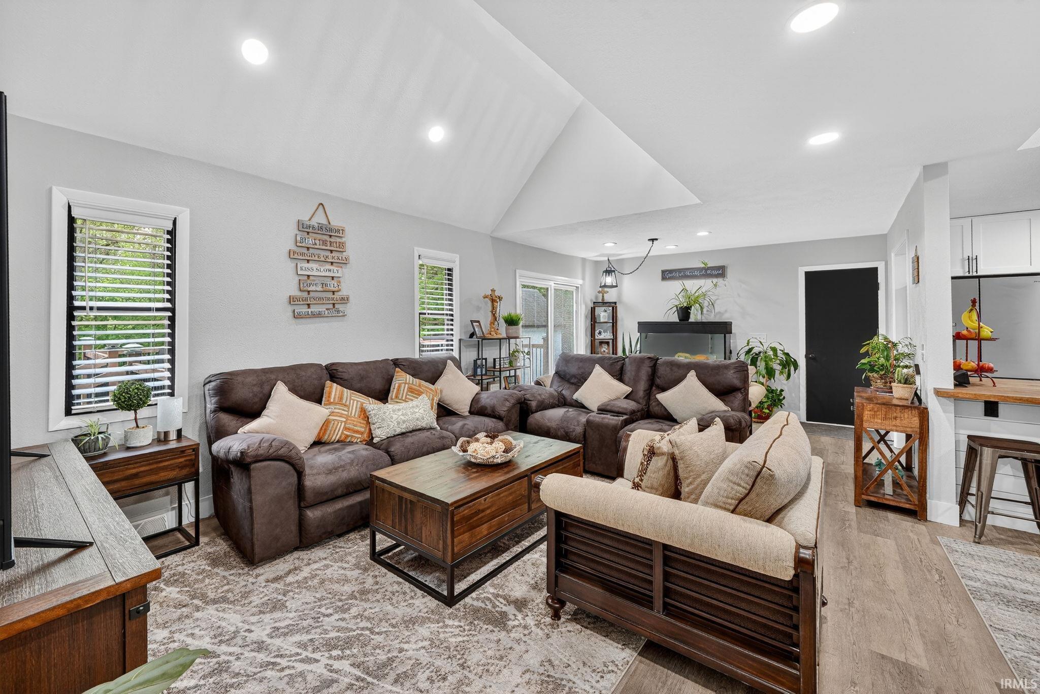 Image 3: Open-concept living area featuring a vaulted ceiling with recessed lighting, Living Room