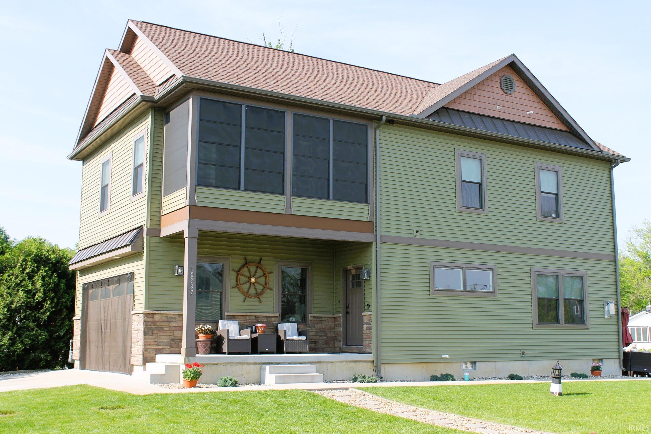 Image 2: Two-story exterior with light green siding and a brown shingle roof, Side View