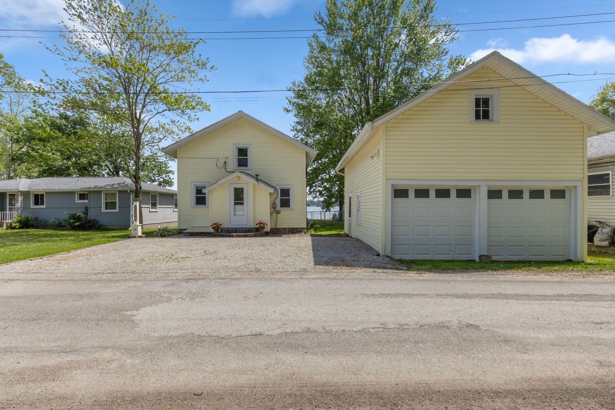 Image 1: Exterior featuring a two-story residence with light yellow siding and a covered front entry, Front Of Structure Image 1: Exterior featuring a two-story residence with light yellow siding and a covered front entry, Front Of Structure