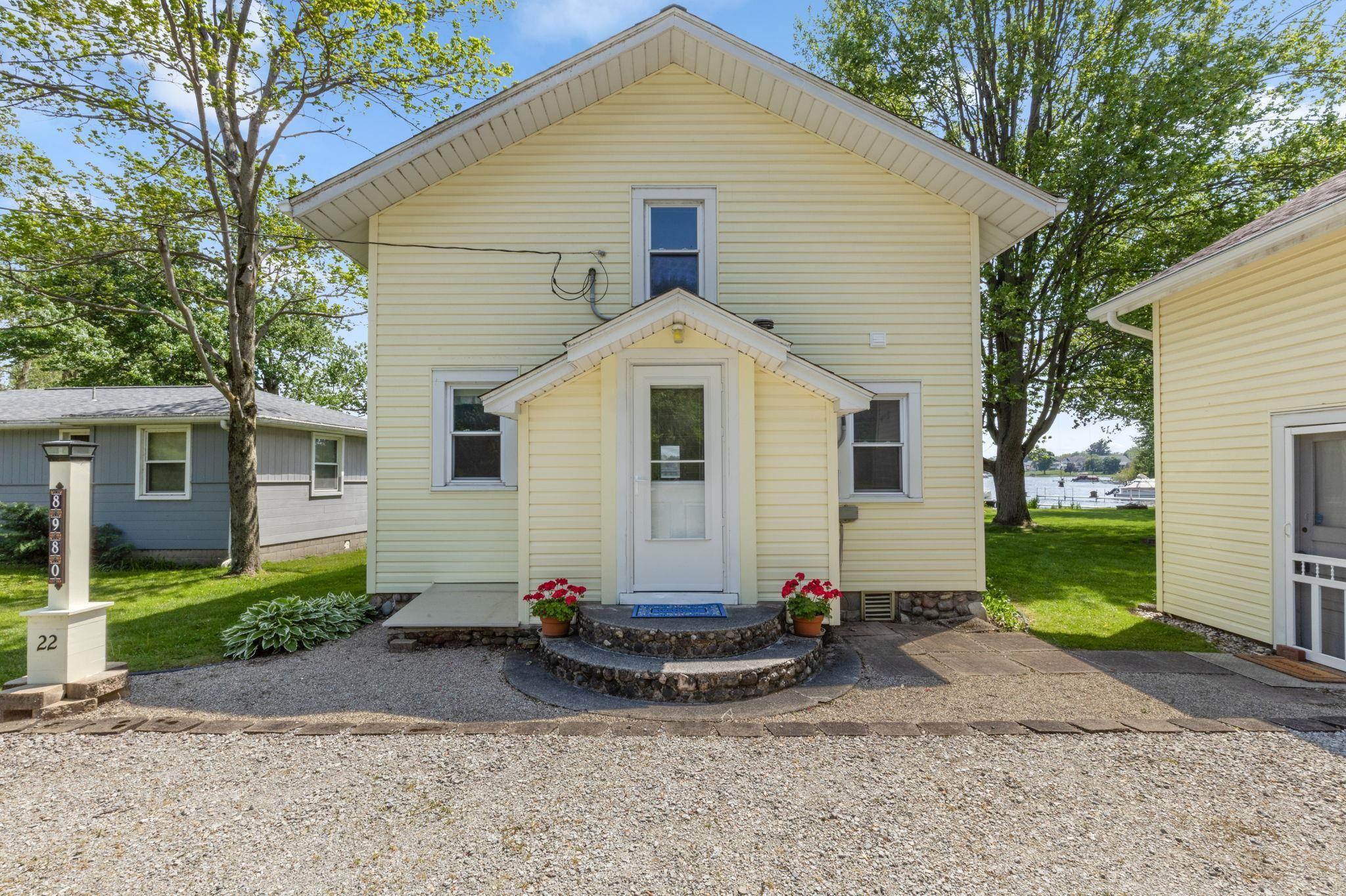 Image 2: Yellow siding exterior with a pitched roofline and white trim, Back Of Structure Image 2: Yellow siding exterior with a pitched roofline and white trim, Back Of Structure