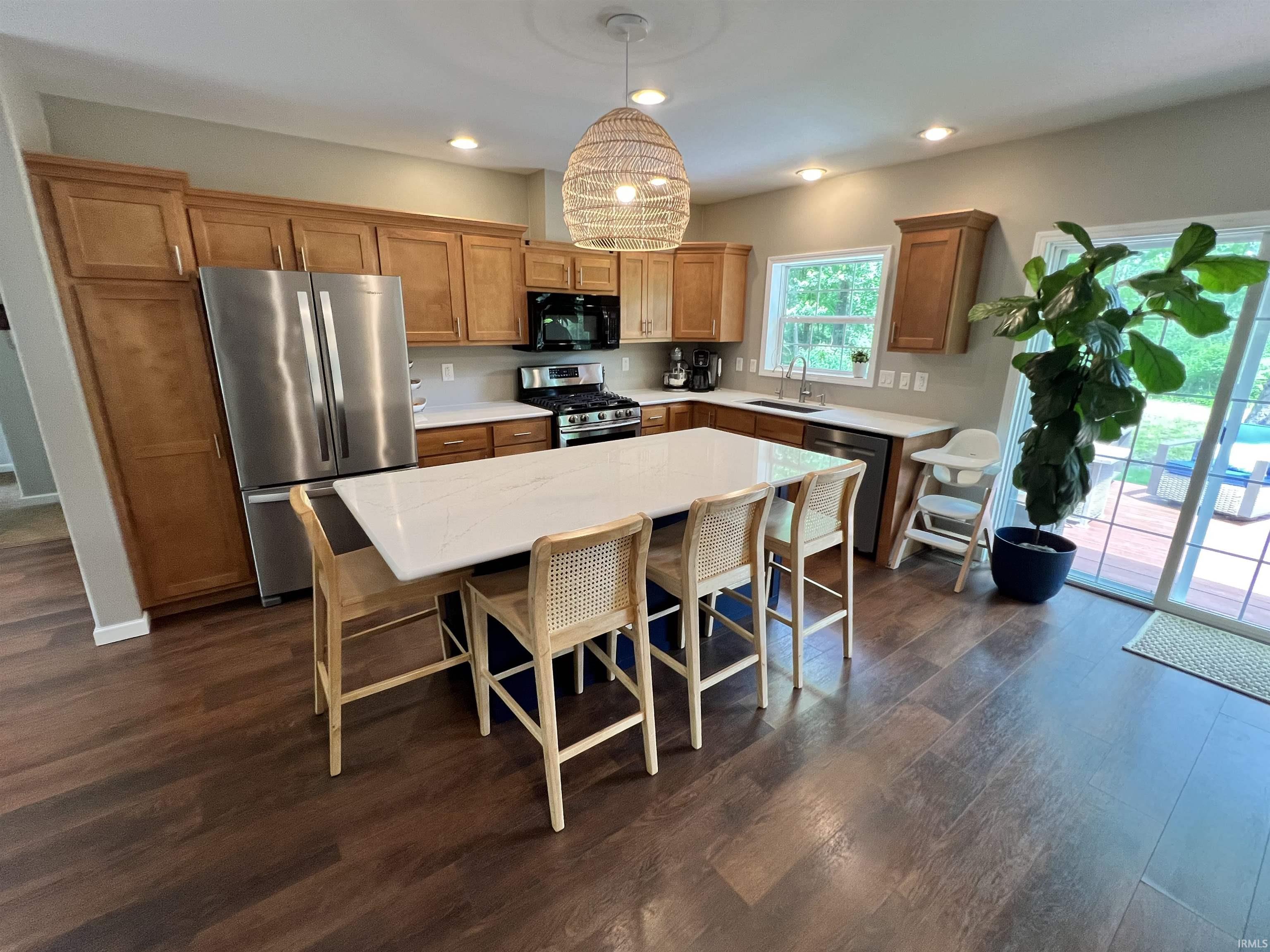 Image 3: Spacious kitchen featuring an expansive island with a white countertop, recessed lighting, wood-finish flooring, and light wood cabinetry, Kitchen