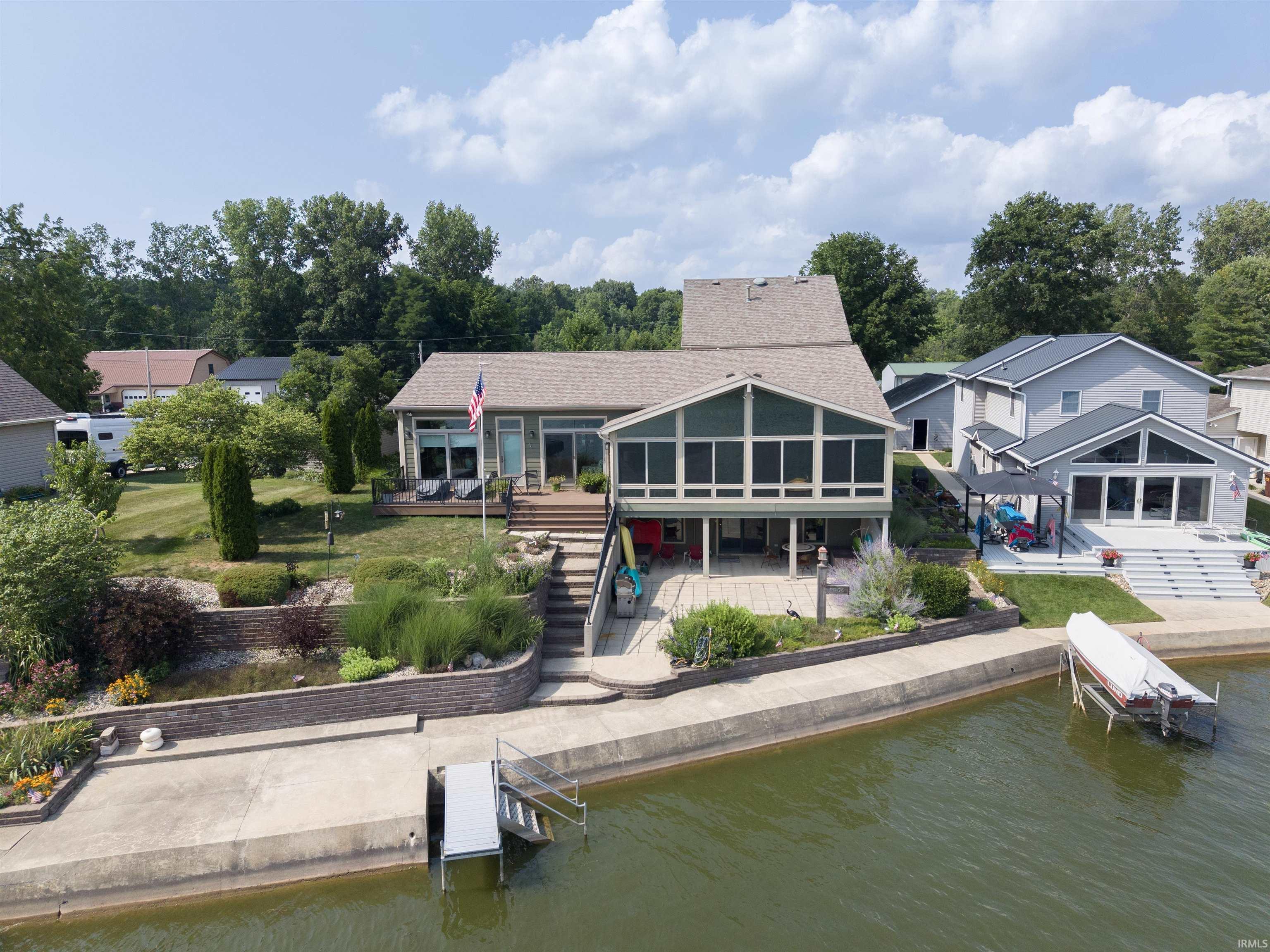 Image 1: Lakefront residence featuring a screened-in porch and an expansive lower-level patio, Back Of Structure Image 1: Lakefront residence featuring a screened-in porch and an expansive lower-level patio, Back Of Structure