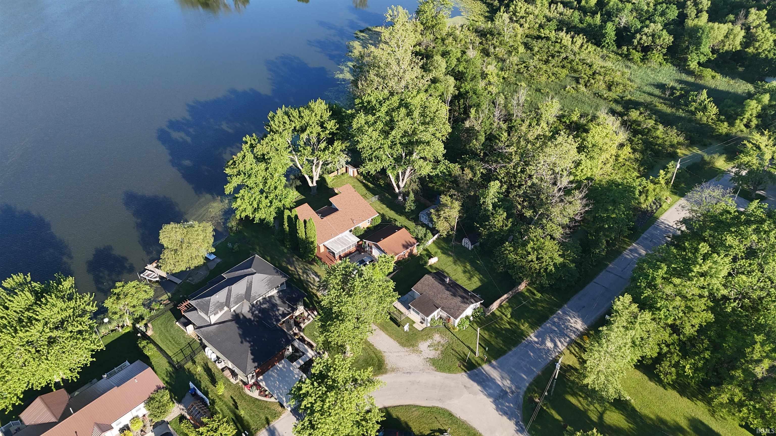 Image 3: Waterfront property featuring extensive shoreline frontage, mature surrounding trees, and a private dock structure, Aerial View Image 3: Waterfront property featuring extensive shoreline frontage, mature surrounding trees, and a private dock structure, Aerial View