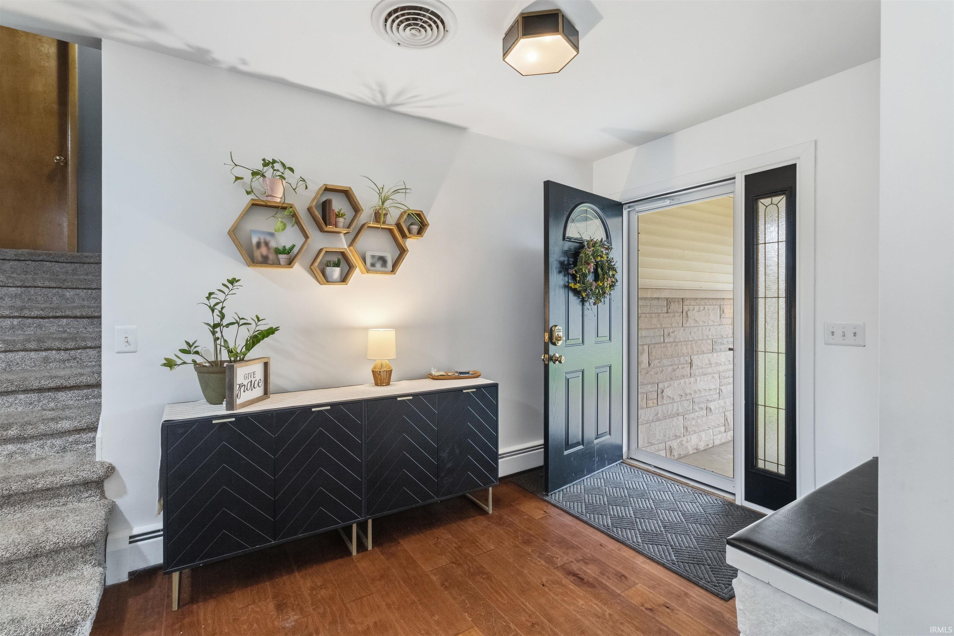 Image 3: Foyer entrance with a baseboard radiator and dark wood finished floors, Entrance Foyer