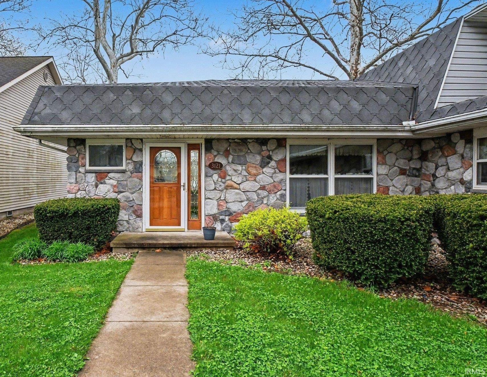 Image 2: Doorway to property featuring a lawn and stone siding, Entry