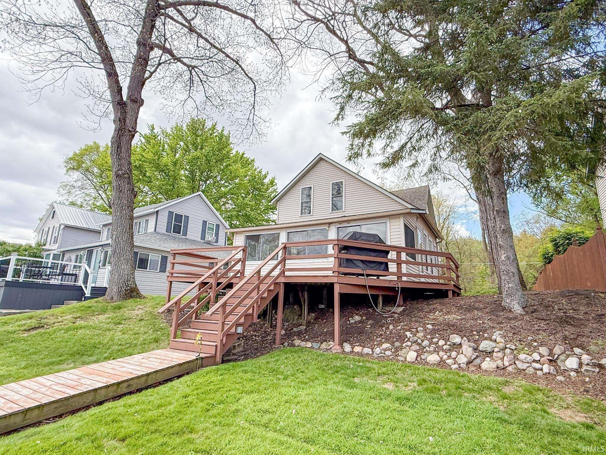 Image 2: Waterfront property with a spacious deck, direct dock access, and a sloped, grassed lawn, Back Of Structure