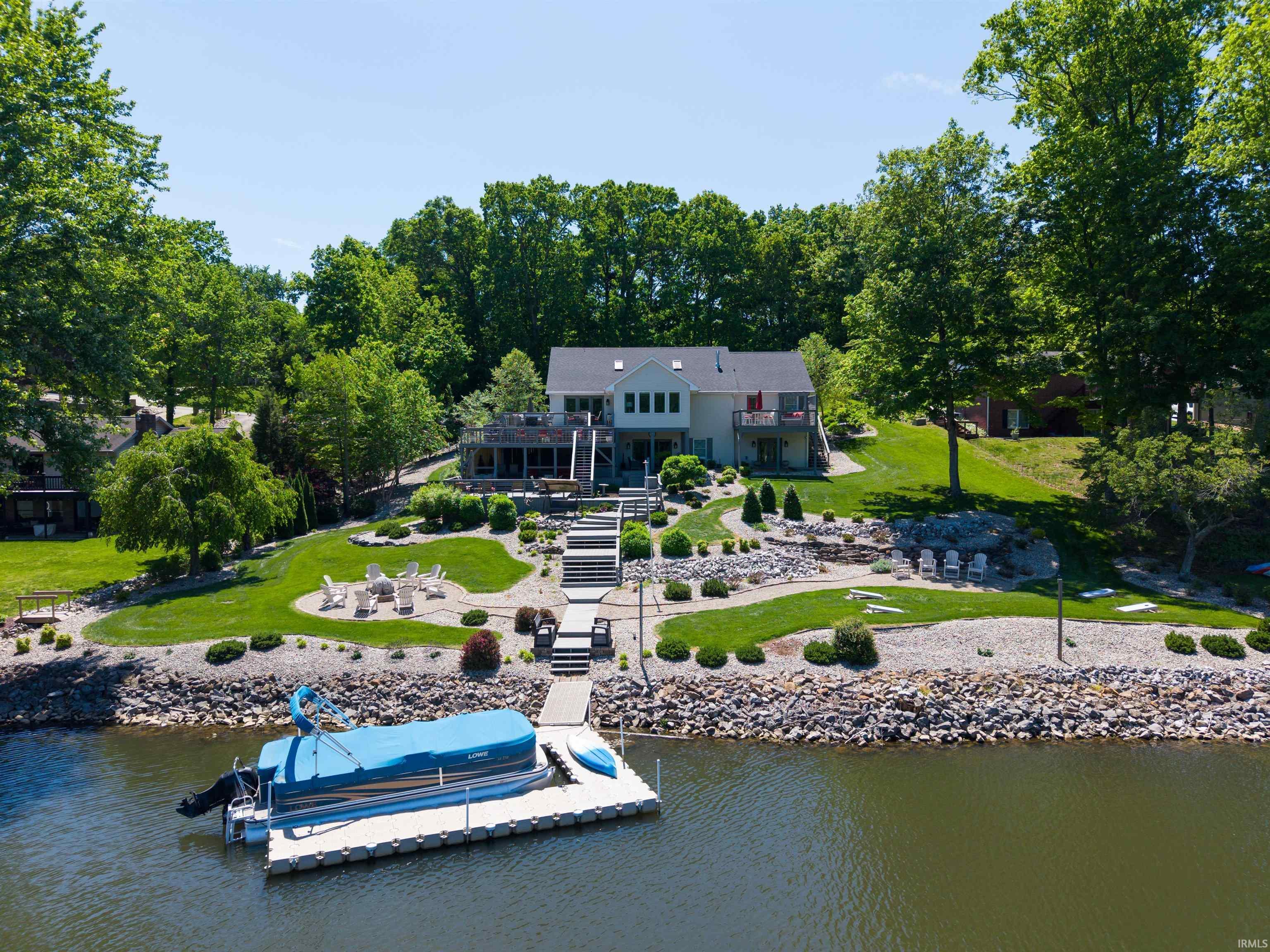 Image 2: Waterfront property featuring a private dock, multi-level decks, a meticulously landscaped terraced lawn, and a stone-lined shoreline, Back Of Structure Image 2: Waterfront property featuring a private dock, multi-level decks, a meticulously landscaped terraced lawn, and a stone-lined shoreline, Back Of Structure