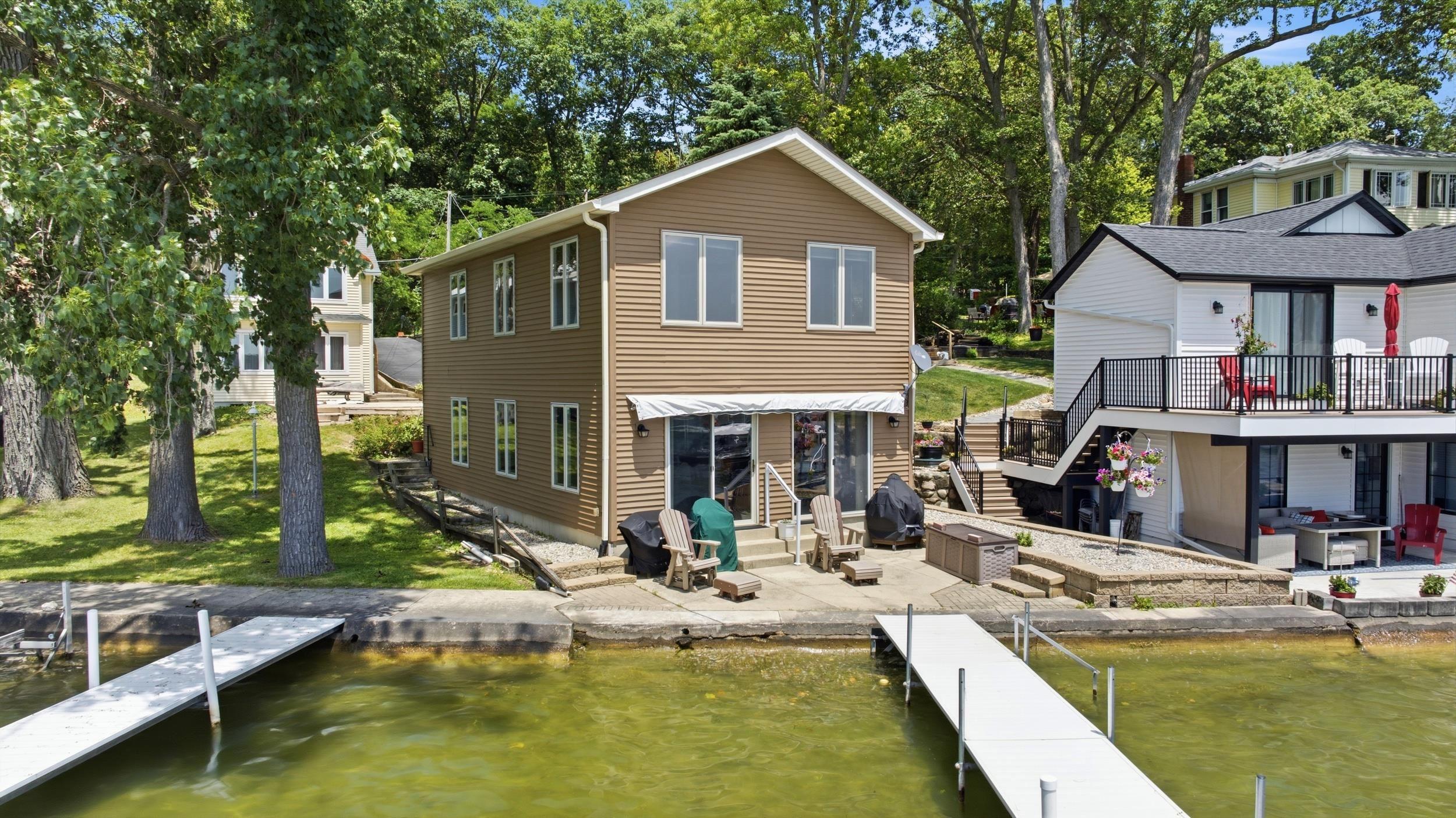 Image 0: Two-story waterside residence featuring light brown horizontal siding, Back Of Structure Image 0: Two-story waterside residence featuring light brown horizontal siding, Back Of Structure