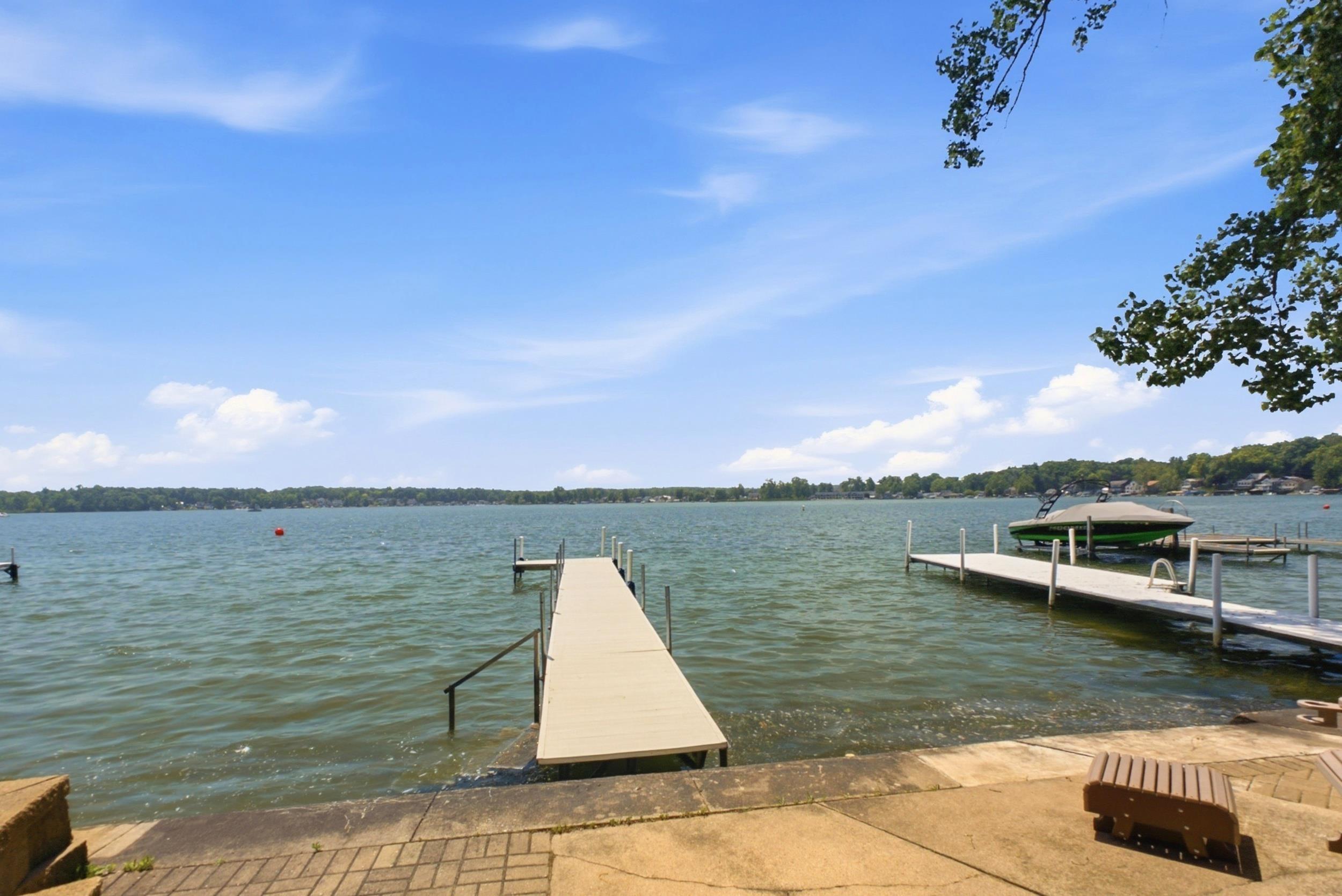 Image 3: Waterfront property featuring a long dock extending into the lake, a second dock with a boat lift, and a concrete patio with brick accents, Dock Image 3: Waterfront property featuring a long dock extending into the lake, a second dock with a boat lift, and a concrete patio with brick accents, Dock
