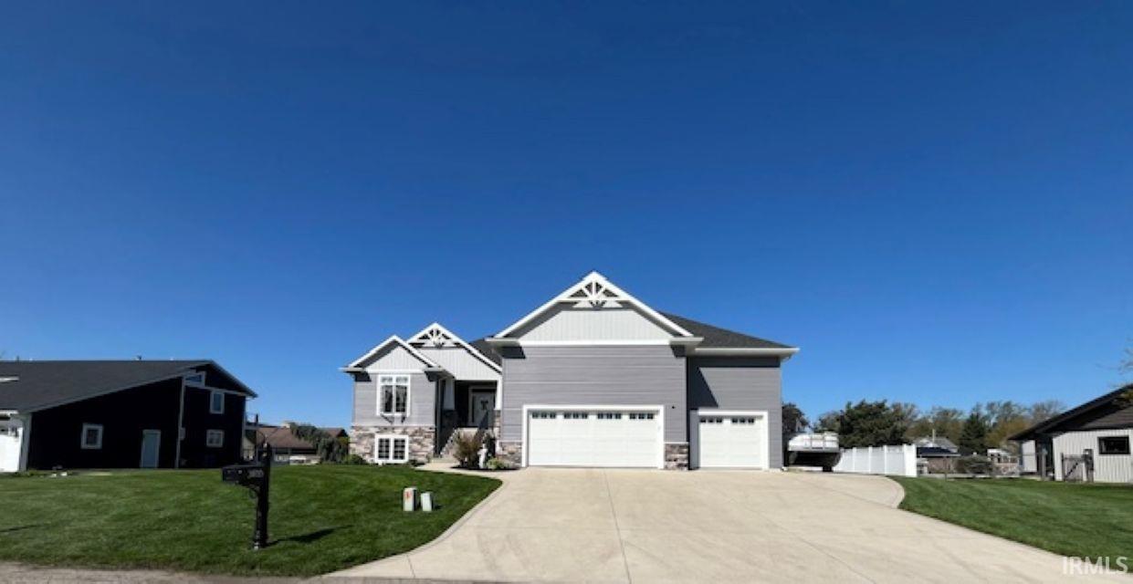 Image 0: Contemporary home featuring grey siding with stone accents, a multi-gabled roofline, and an integrated two-car garage, Front Of Structure