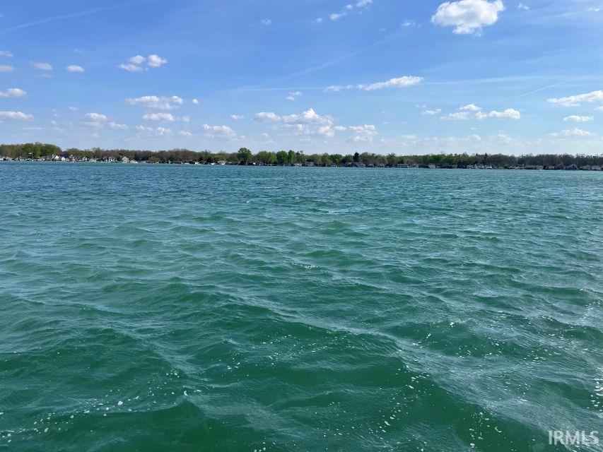Image 3: Expansive waterfront with a distant shoreline featuring residential properties and mature trees, View