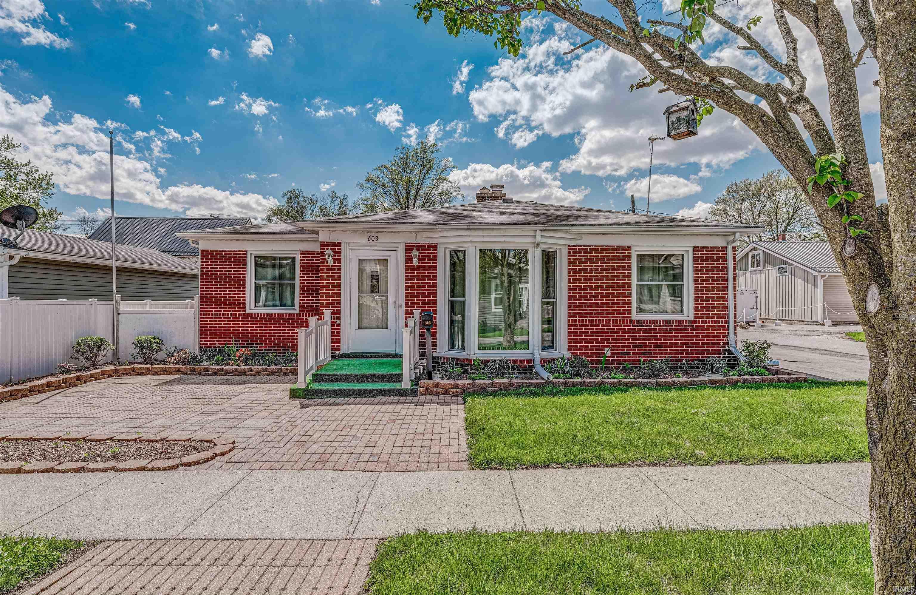 Image 0: Brick exterior featuring a bay window, white trim, and a manicured front lawn, Front Of Structure Image 0: Brick exterior featuring a bay window, white trim, and a manicured front lawn, Front Of Structure
