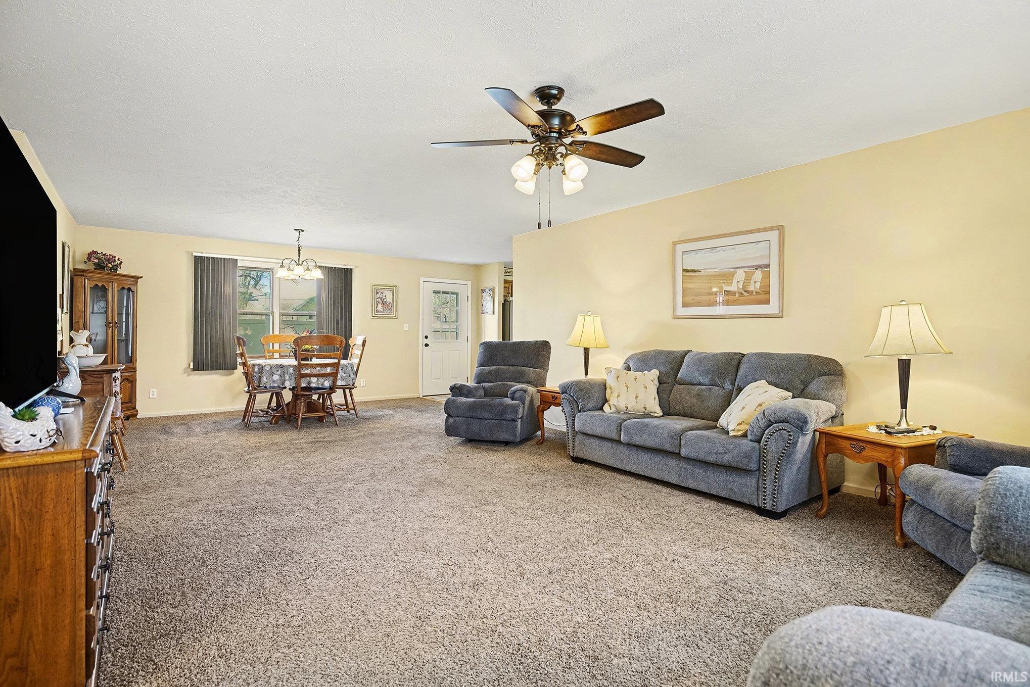 Image 2: Living room featuring carpet floors, a chandelier, and a ceiling fan, Living Room