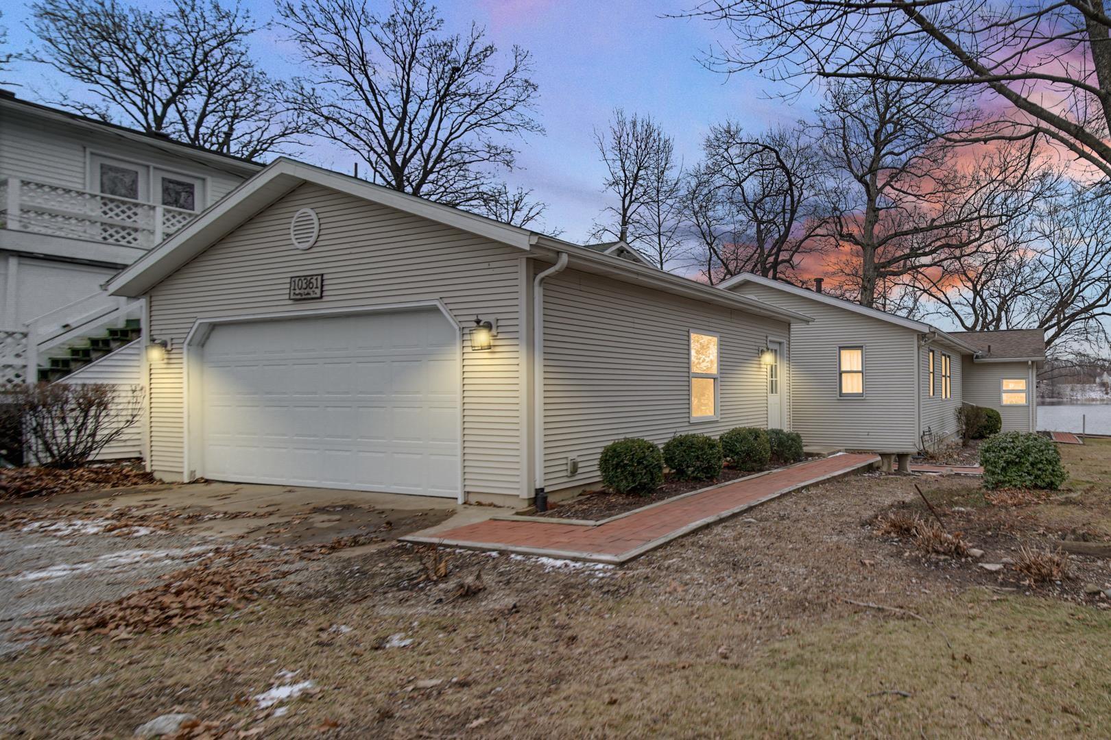 Image 2: Property exterior at dusk featuring driveway and an attached garage, Back of home