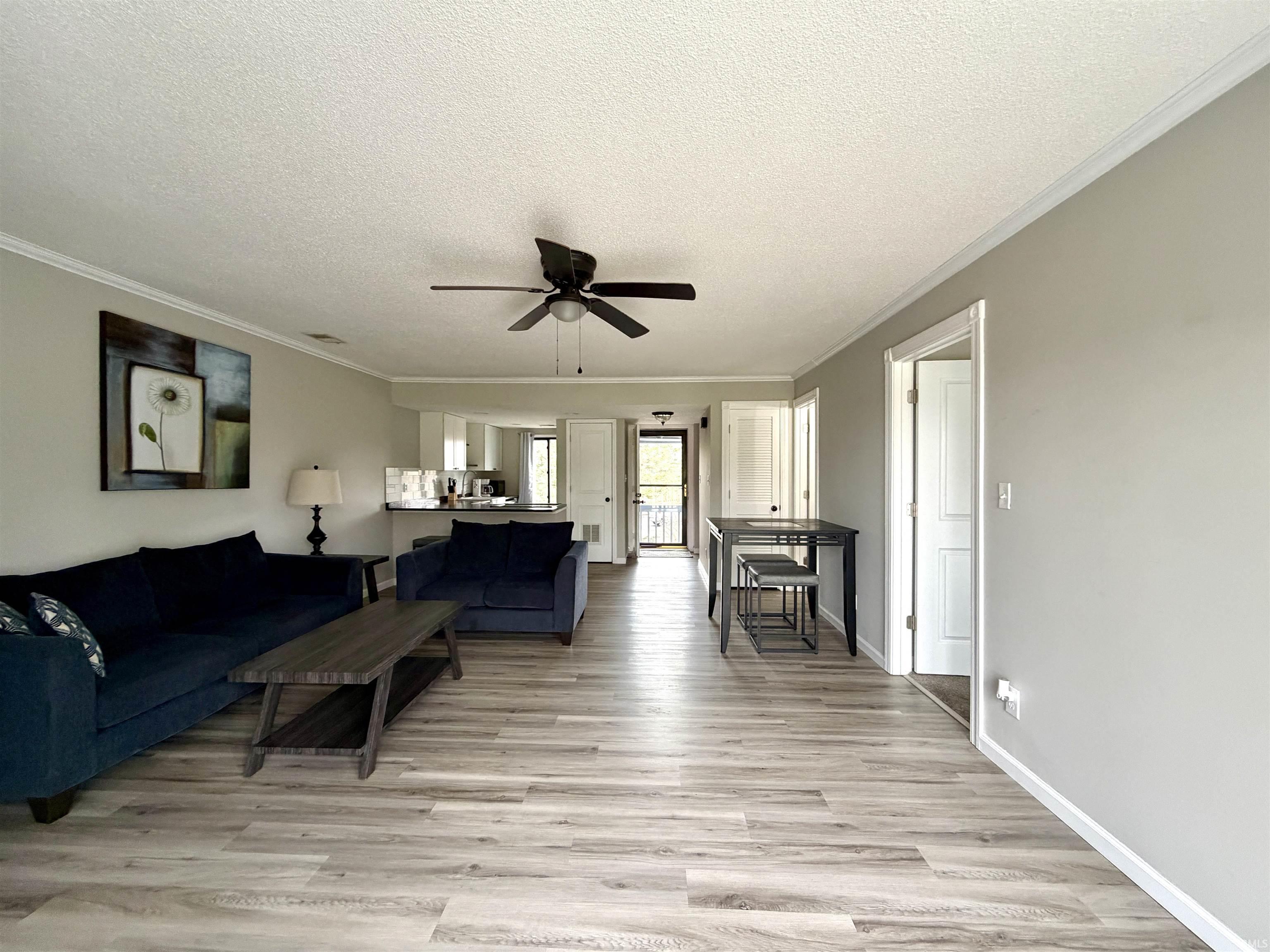 Image 3: Living room with a textured ceiling, light wood-style flooring, ceiling fan, and ornamental molding, Living Room