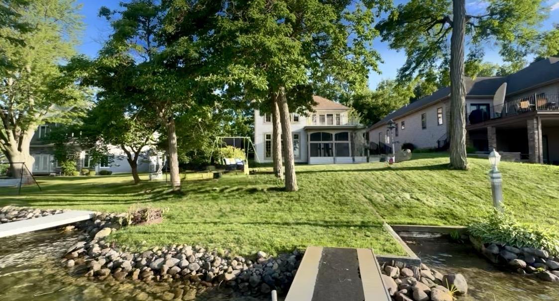 Image 1: View from lake james featuring a water view and a sunroom, Level Lakefront Lot/yard