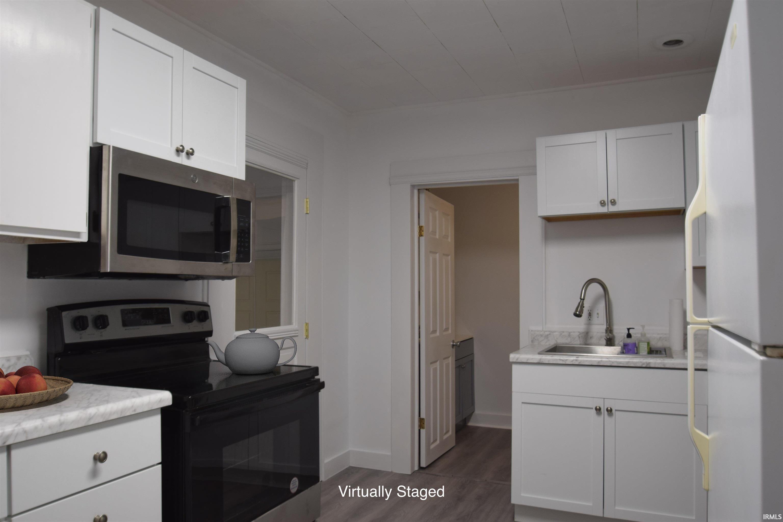 Image 3: Kitchen featuring white cabinetry with silver hardware, stone-look countertops, and an undermount stainless steel sink with a gooseneck faucet, Kitchen with virtual staging Image 3: Kitchen featuring white cabinetry with silver hardware, stone-look countertops, and an undermount stainless steel sink with a gooseneck faucet, Kitchen with virtual staging