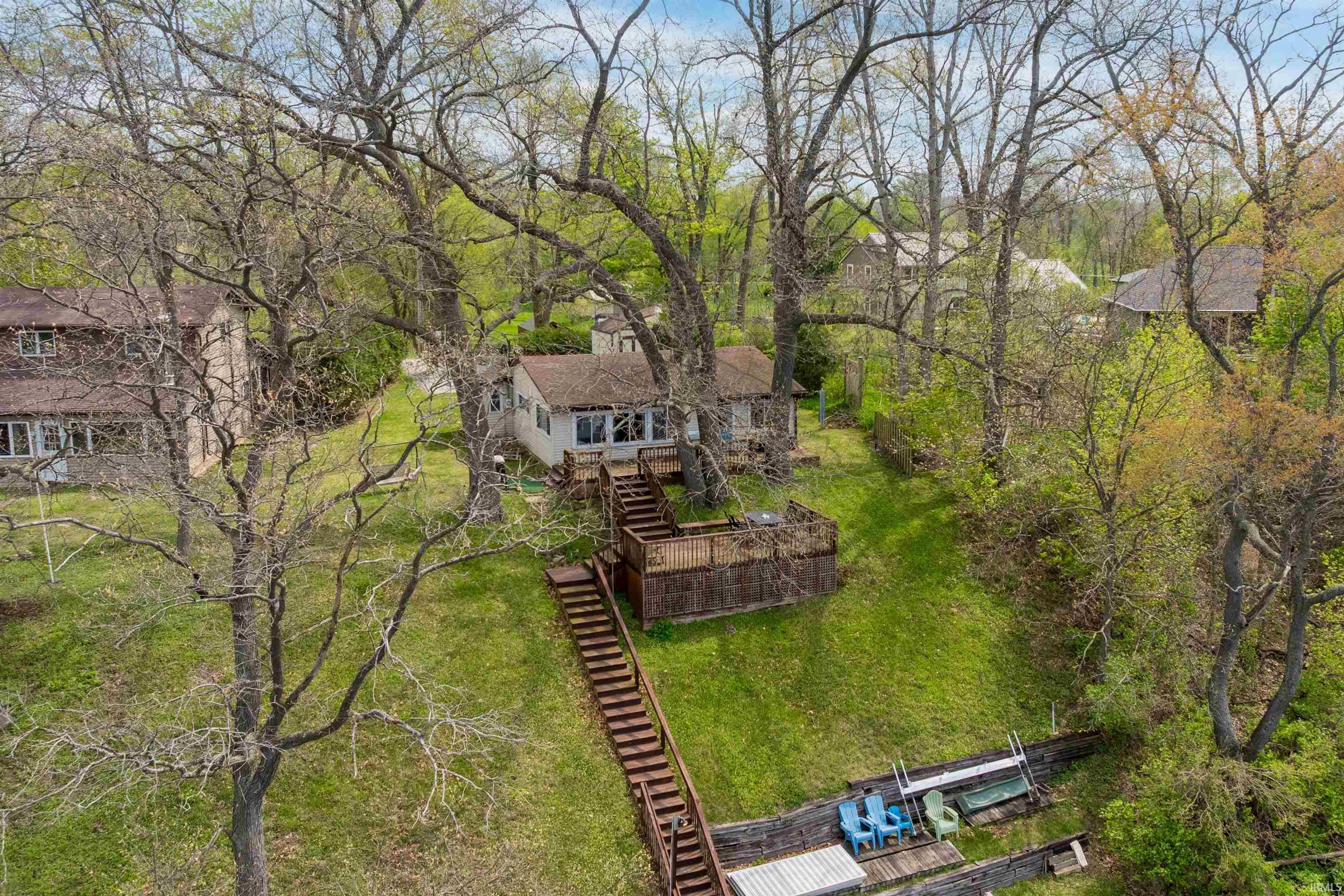 Image 1: Waterfront property featuring a sloped lawn, extensive wooden staircase, and a private dock structure, Aerial View Image 1: Waterfront property featuring a sloped lawn, extensive wooden staircase, and a private dock structure, Aerial View