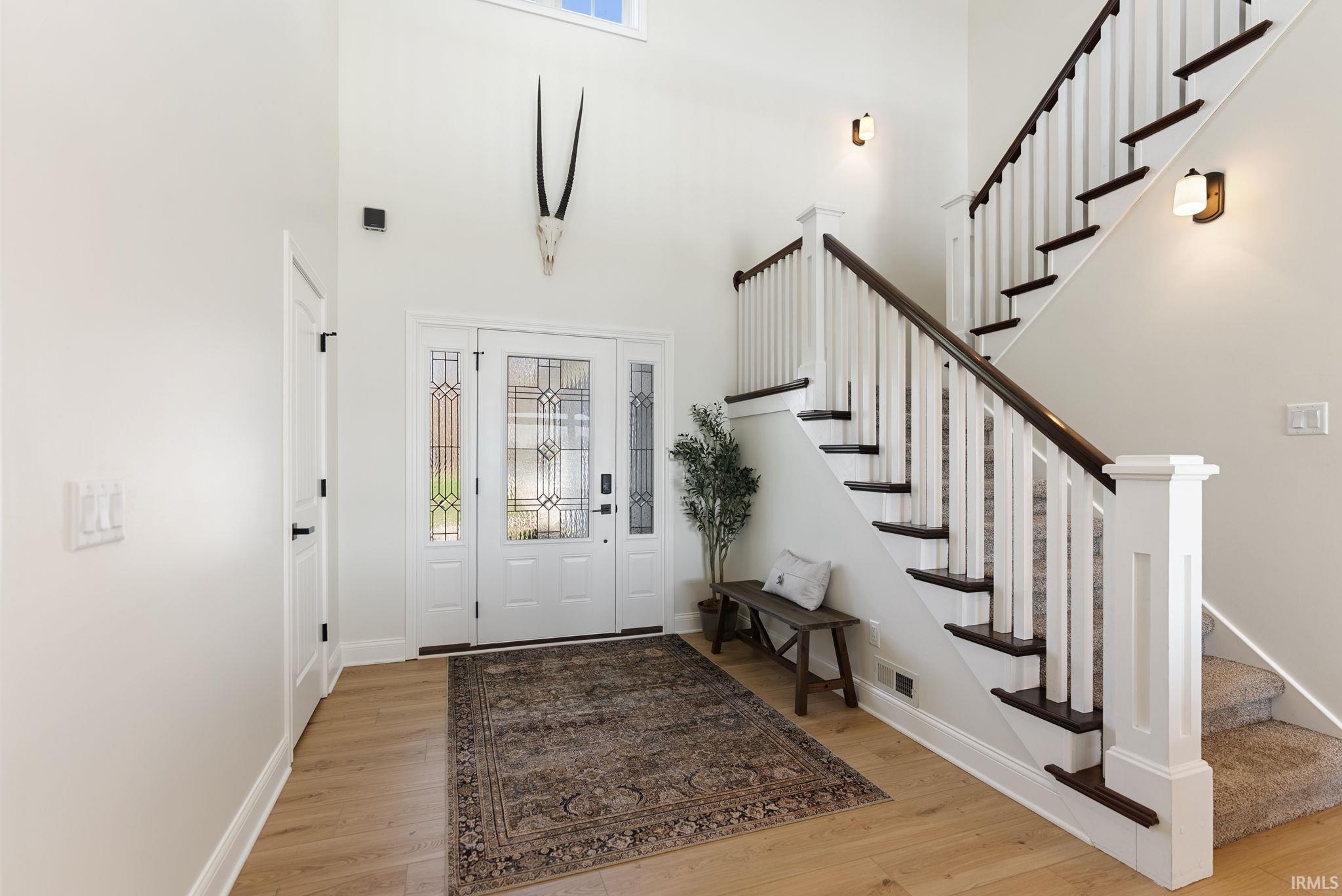 Image 3: Entryway with light wood-style floors, a high ceiling, and healthy amount of natural light, Entrance Foyer