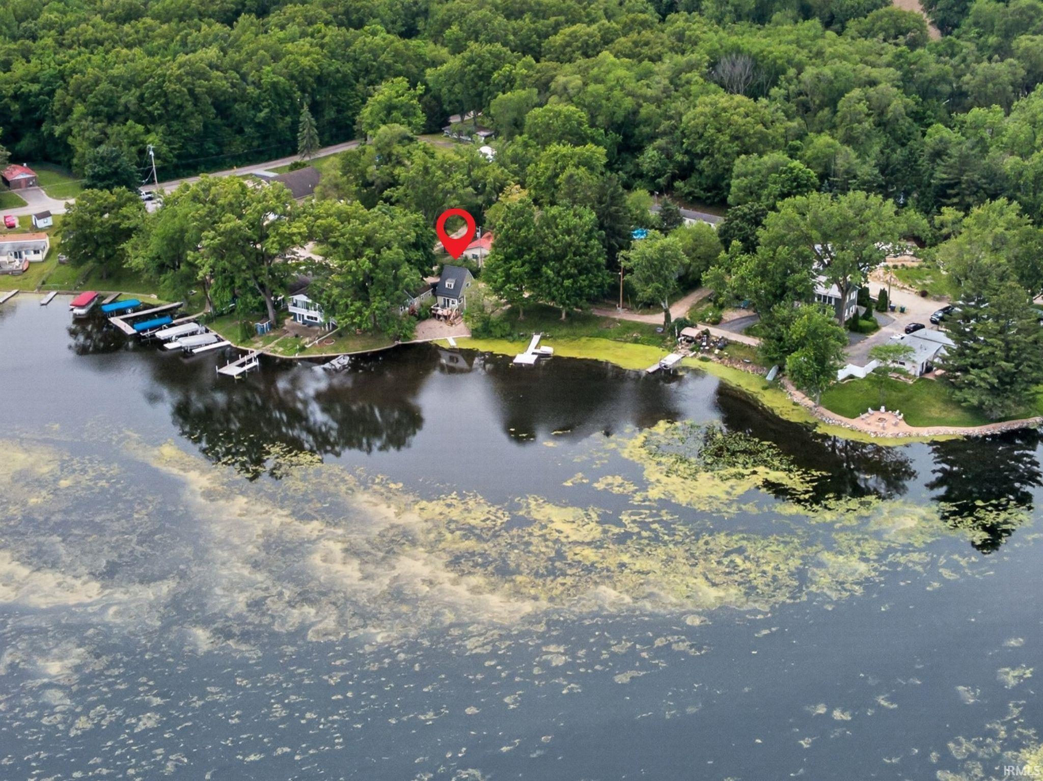 Image 2: Waterfront property featuring a private dock, expansive green space, mature trees, and a paved driveway, Aerial View Image 2: Waterfront property featuring a private dock, expansive green space, mature trees, and a paved driveway, Aerial View