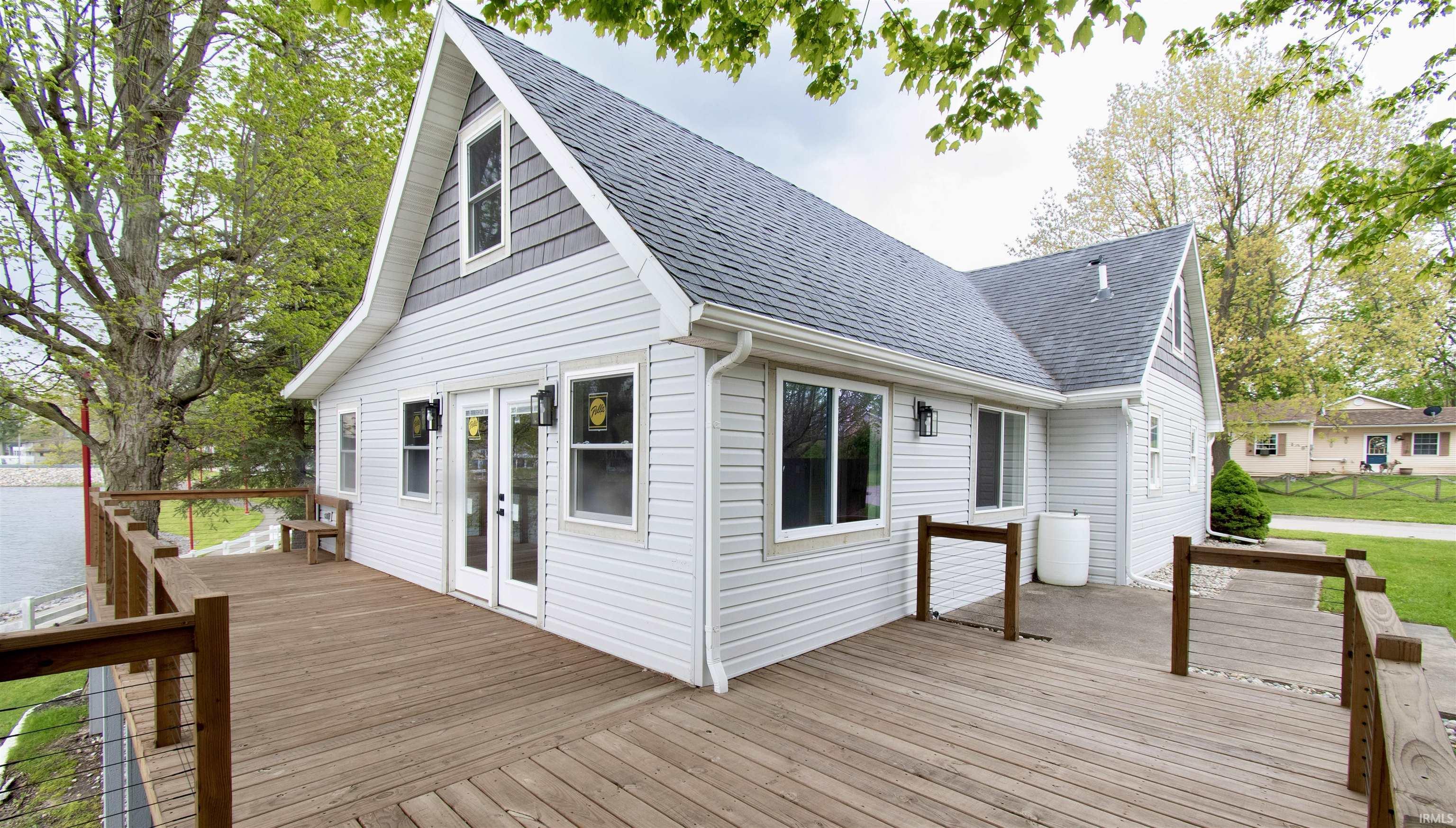 Image 1: Spacious outdoor deck with wood railings, overlooking a body of water, Deck Image 1: Spacious outdoor deck with wood railings, overlooking a body of water, Deck