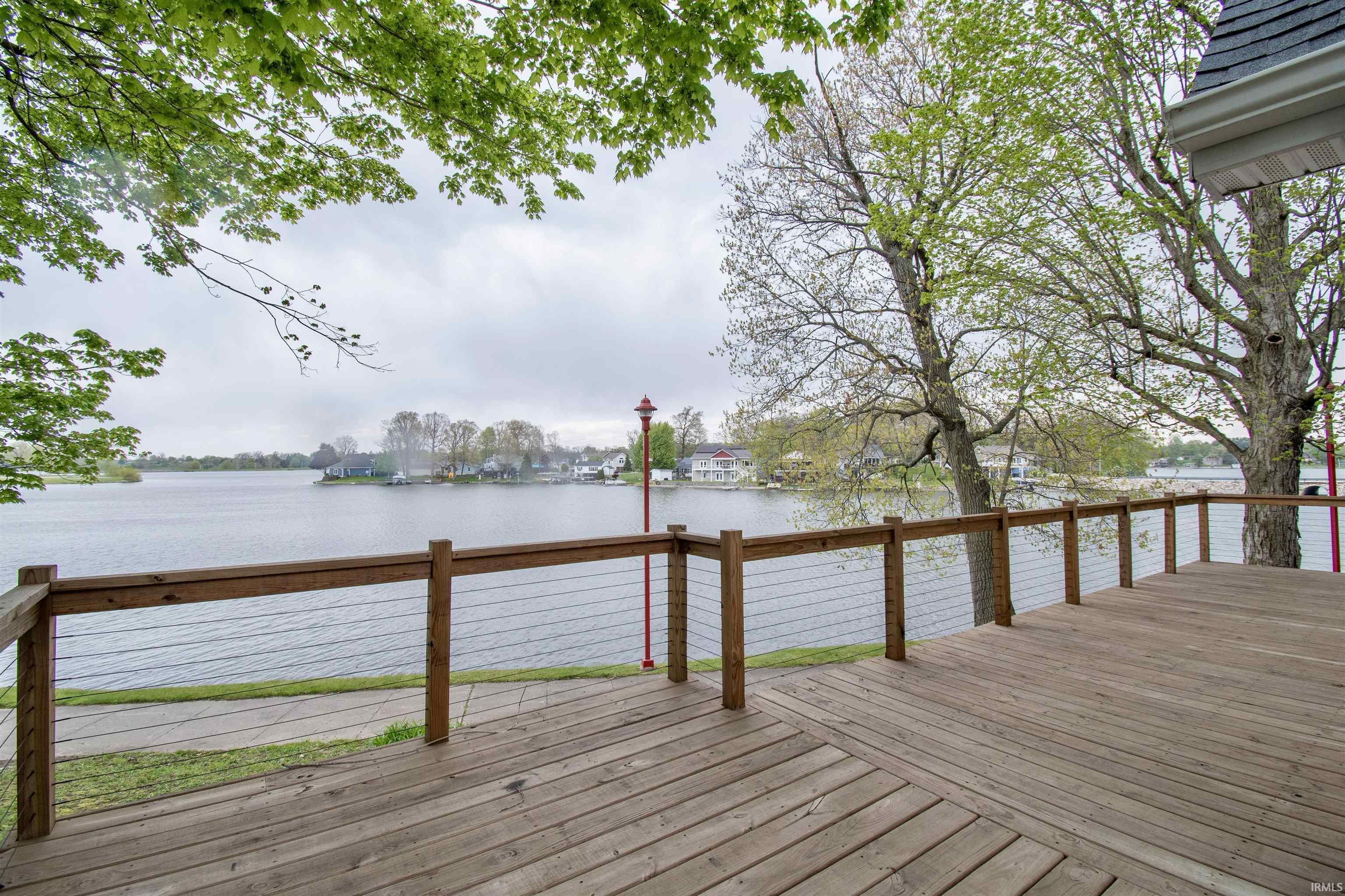 Image 2: Expansive wood deck with cable railing overlooking a lake, Deck Image 2: Expansive wood deck with cable railing overlooking a lake, Deck