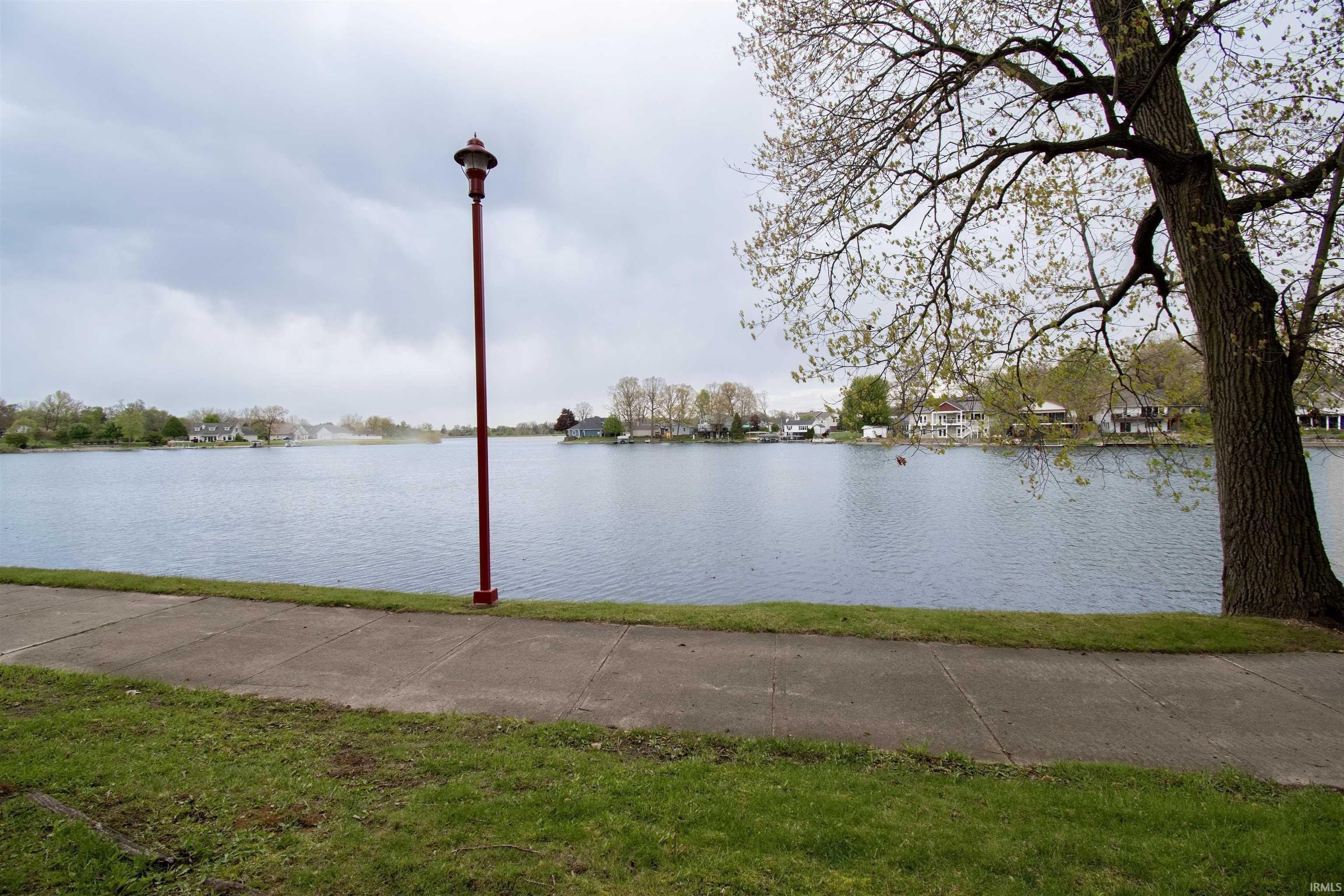 Image 3: Waterfront setting with a concrete pathway and a manicured grassy area, View Image 3: Waterfront setting with a concrete pathway and a manicured grassy area, View