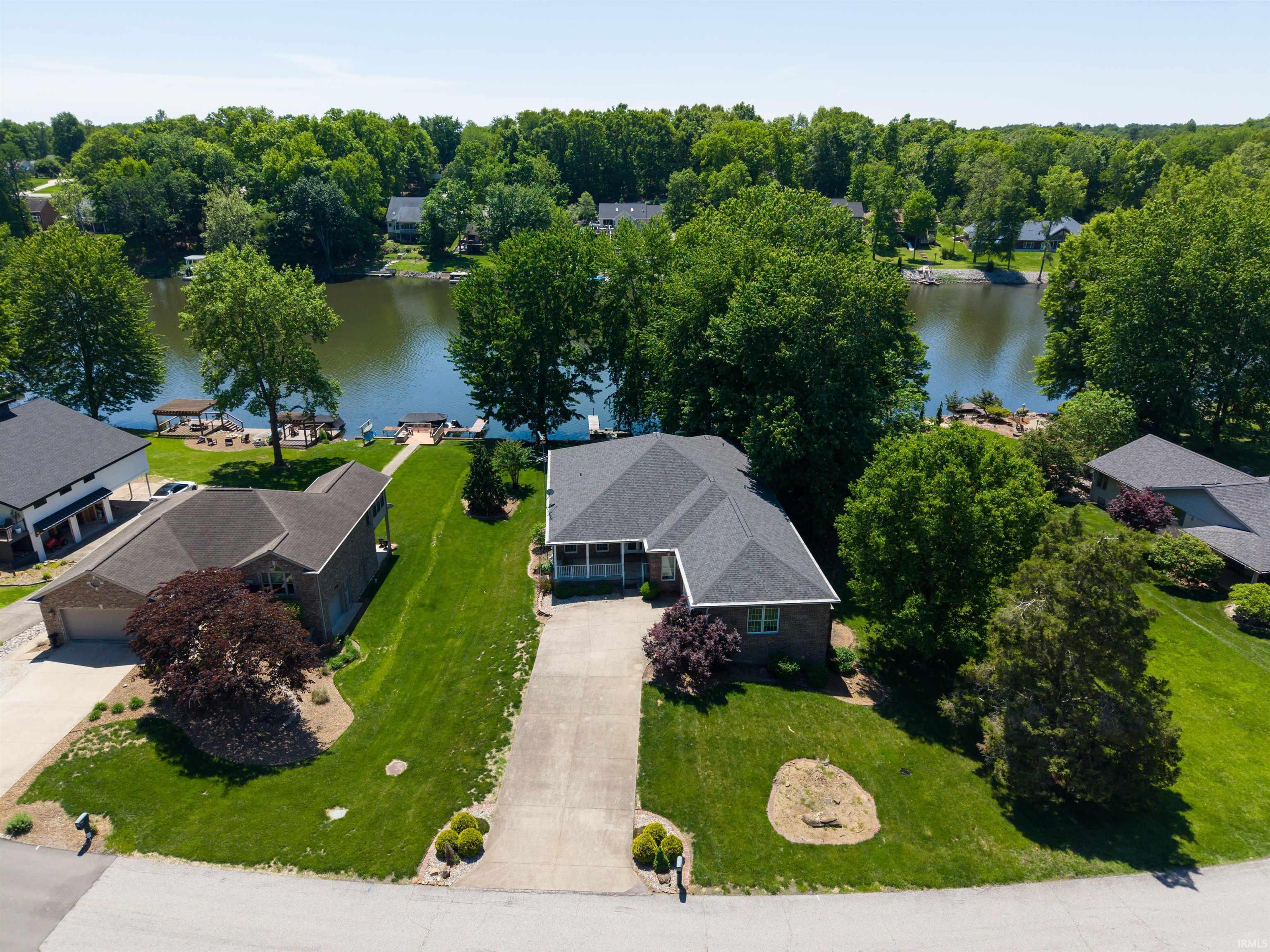 Image 0: Waterfront property featuring an expansive green lawn and mature trees, Aerial View