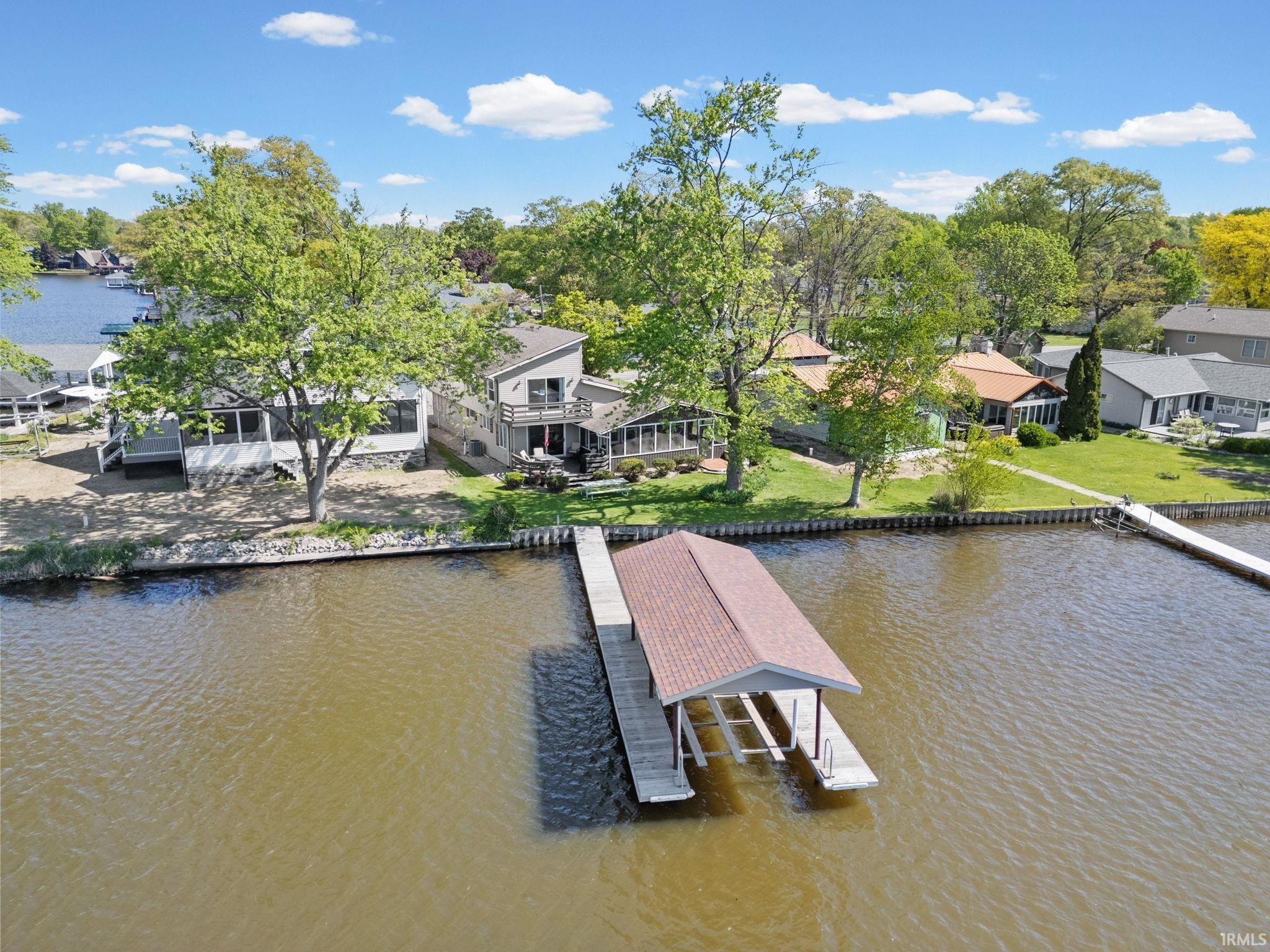 Image 0: Waterfront property featuring a covered boat lift, an additional dock, and a retaining wall, Dock
