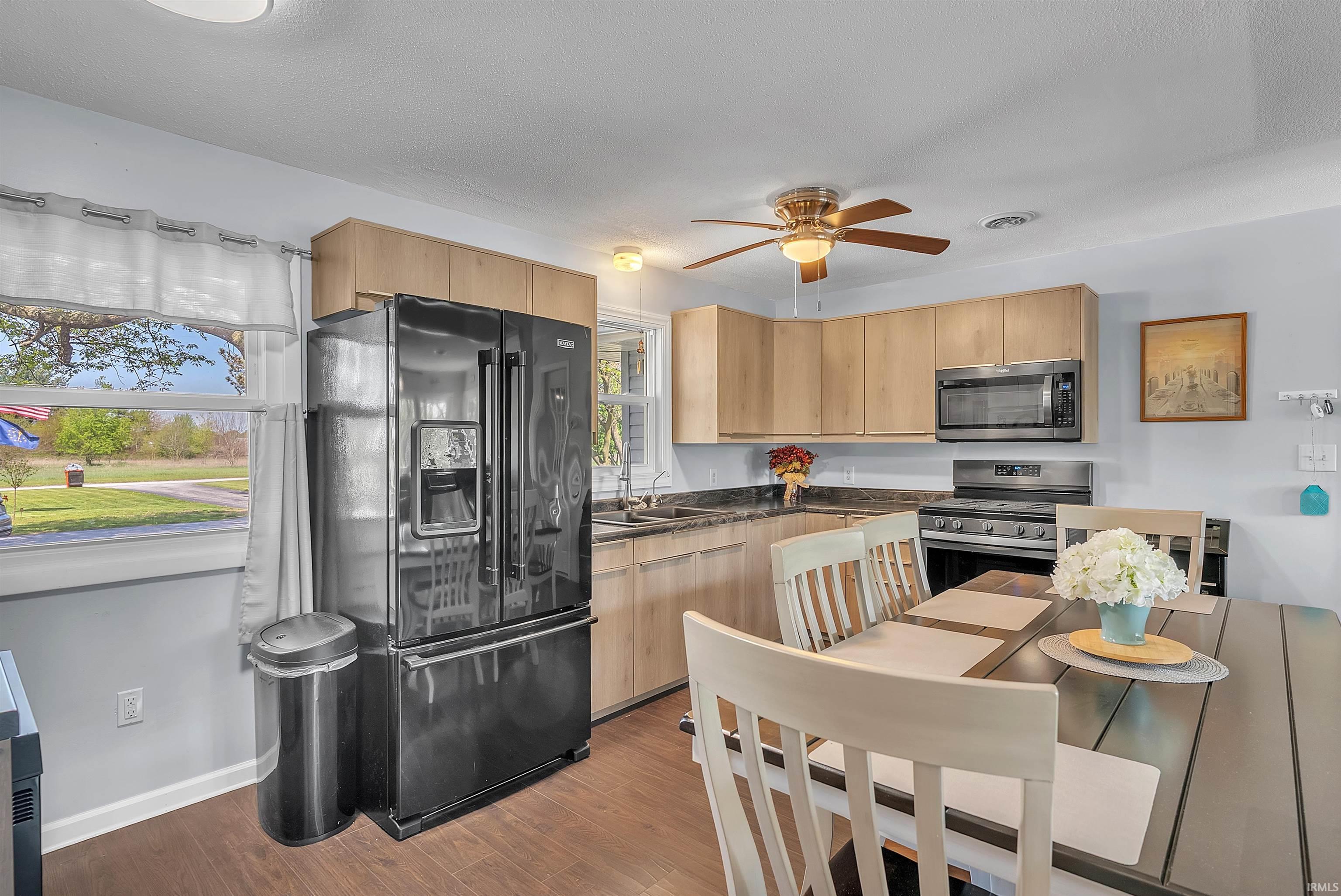 Image 3: Kitchen featuring wood-finish flooring, light wood cabinetry, stone-finish countertops, and a full suite of stainless steel appliances, Kitchen
