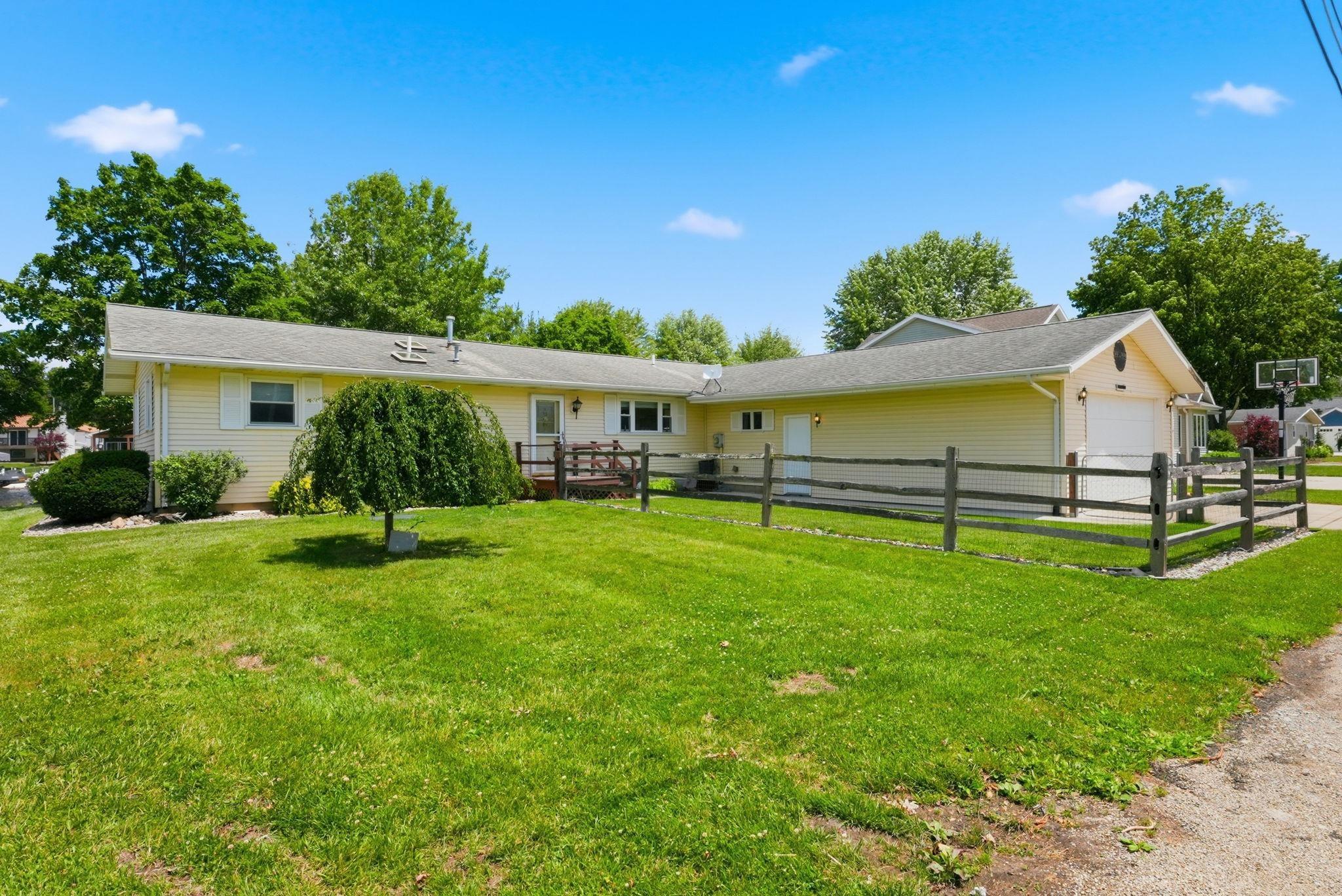 Image 2: Ranch-style exterior with yellow siding, a two-car garage, and a front deck, Front Of Structure