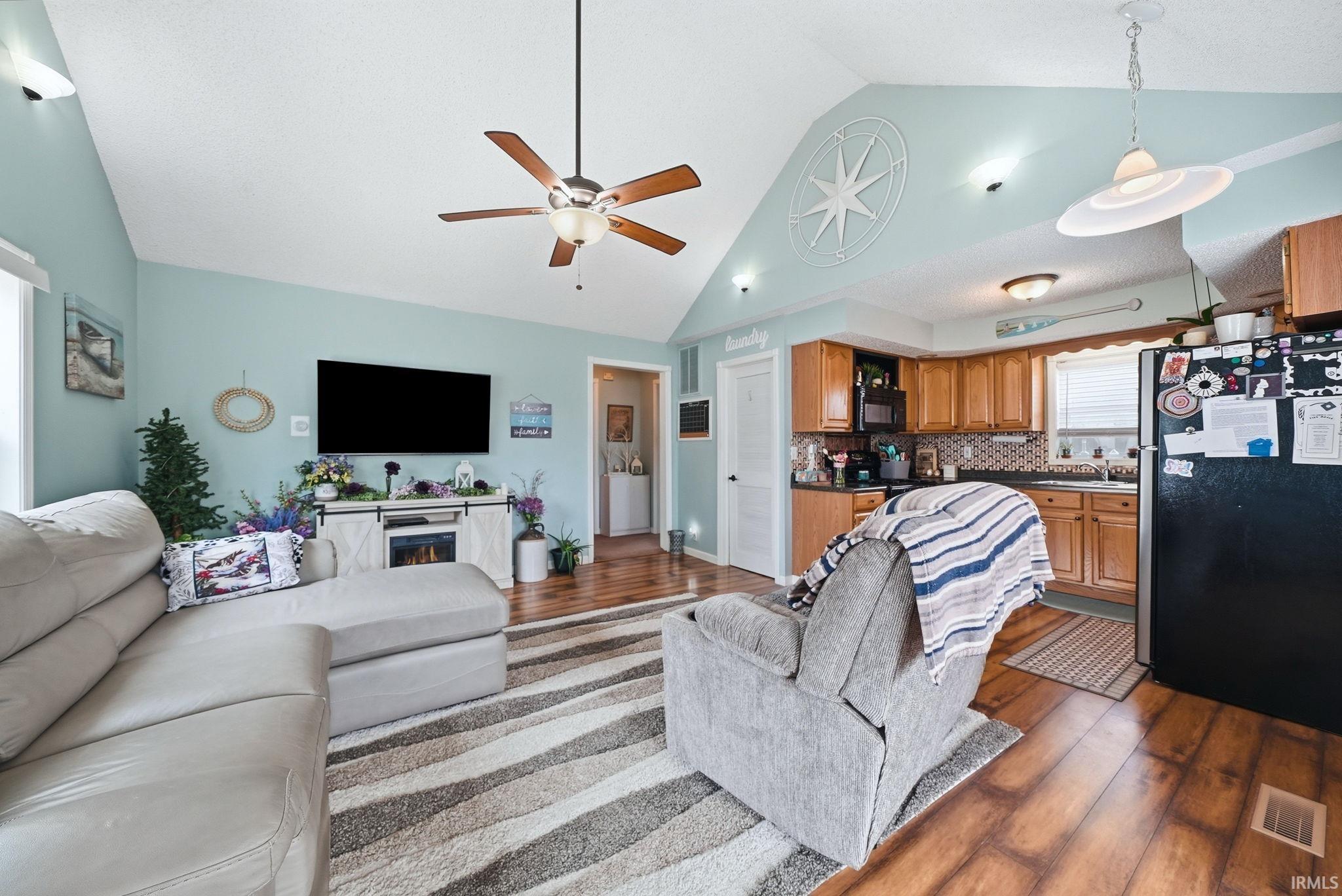 Image 3: Vaulted ceilings define this open living space featuring wood-finish flooring, a ceiling fan, and recessed lighting, Living Room Image 3: Vaulted ceilings define this open living space featuring wood-finish flooring, a ceiling fan, and recessed lighting, Living Room