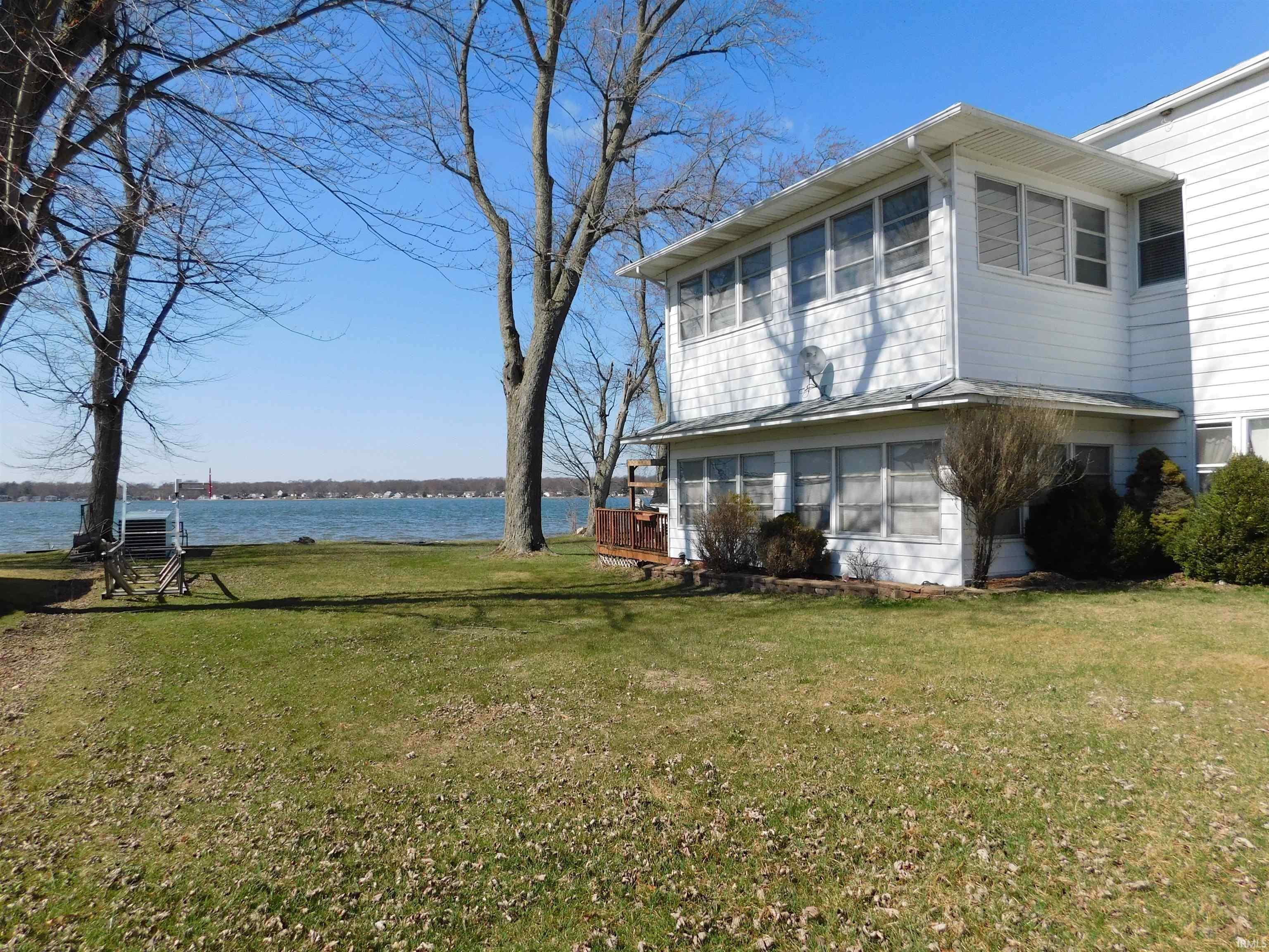 Image 3: View of side of property featuring a lawn and a deck with water view, Side Of Structure Image 3: View of side of property featuring a lawn and a deck with water view, Side Of Structure
