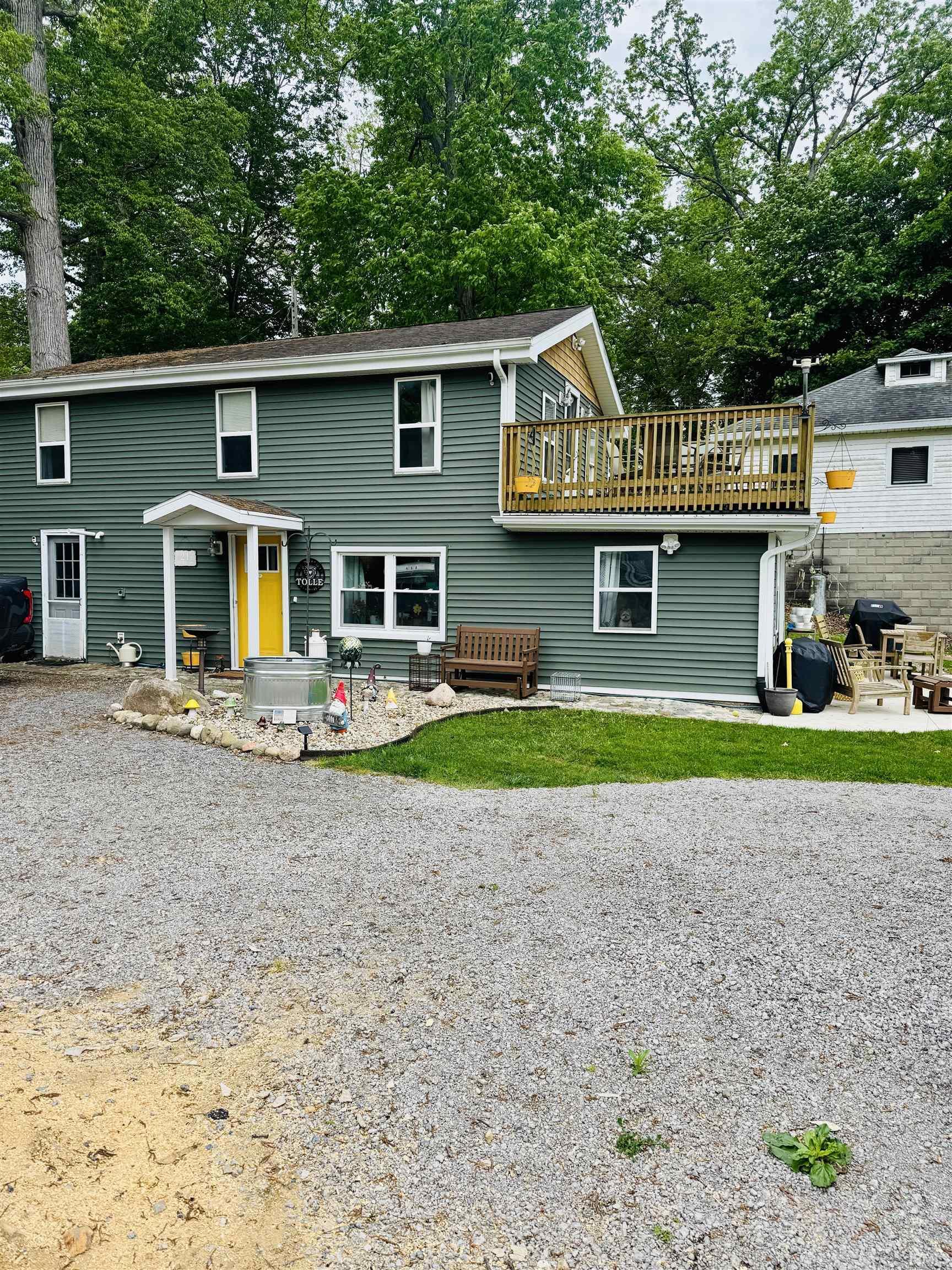 Image 1: Two-story residence featuring green horizontal siding and white trim, Back Of Structure Image 1: Two-story residence featuring green horizontal siding and white trim, Back Of Structure