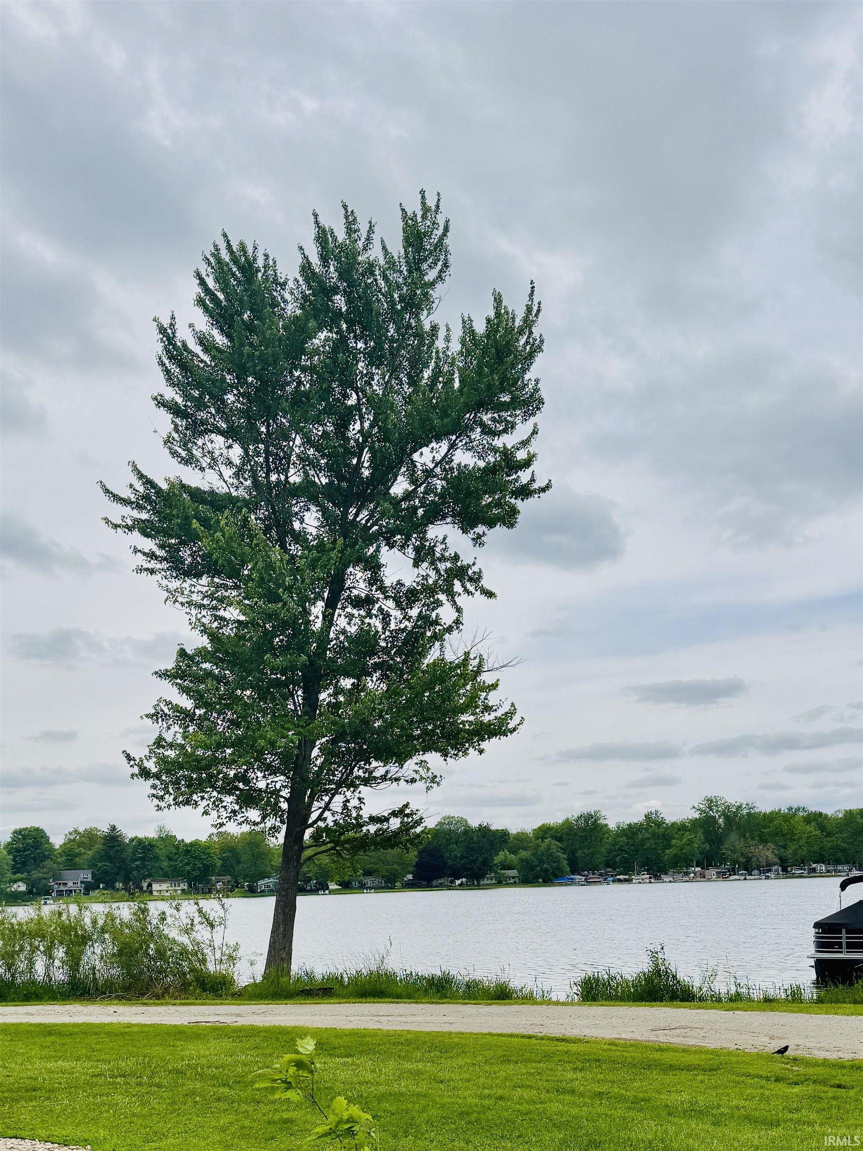 Image 3: Lakeside setting with a mature deciduous tree and manicured green space, View Image 3: Lakeside setting with a mature deciduous tree and manicured green space, View