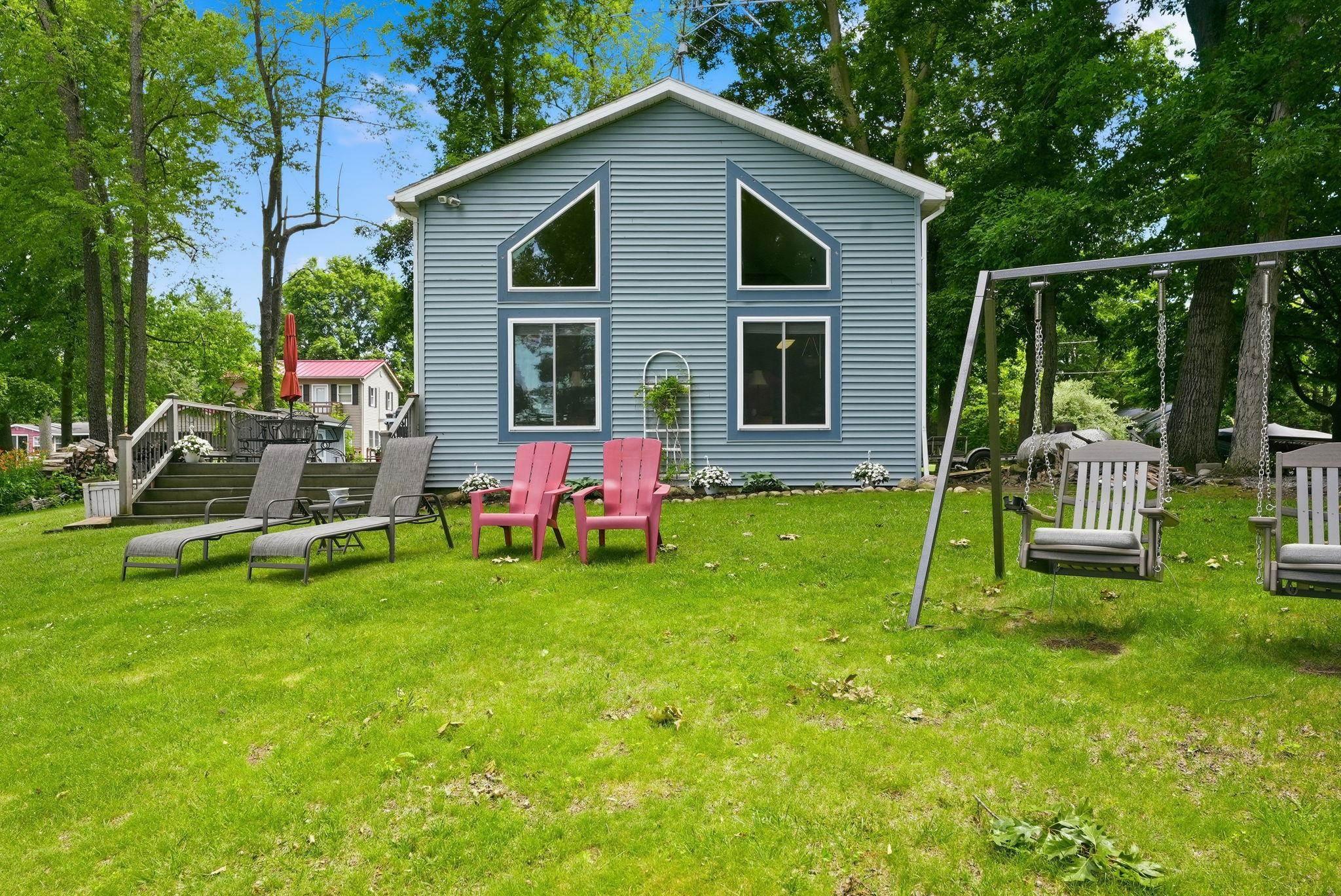 Image 1: Blue siding exterior featuring a prominent gabled roofline and large geometric windows, Back Of Structure Image 1: Blue siding exterior featuring a prominent gabled roofline and large geometric windows, Back Of Structure