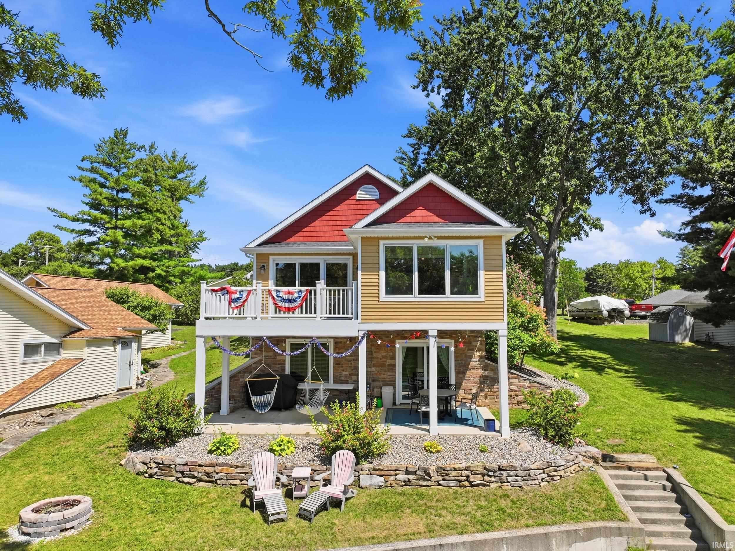 Image 1: Two-story residence featuring a red shingle roof and yellow siding, Back Of Structure Image 1: Two-story residence featuring a red shingle roof and yellow siding, Back Of Structure