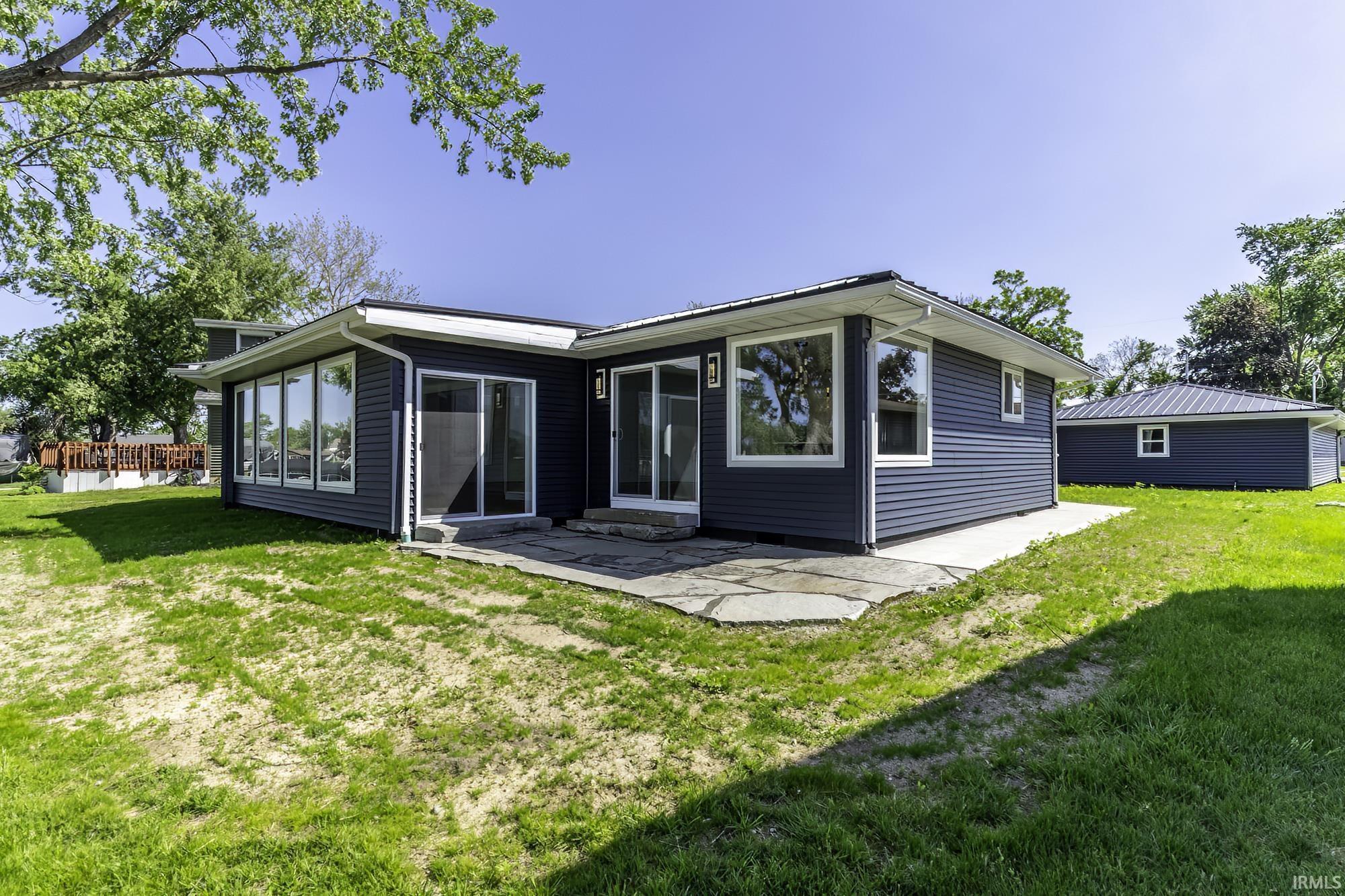 Image 2: Contemporary ranch-style residence featuring dark blue horizontal siding, white trim, and a white fascia, Back Of Structure Image 2: Contemporary ranch-style residence featuring dark blue horizontal siding, white trim, and a white fascia, Back Of Structure